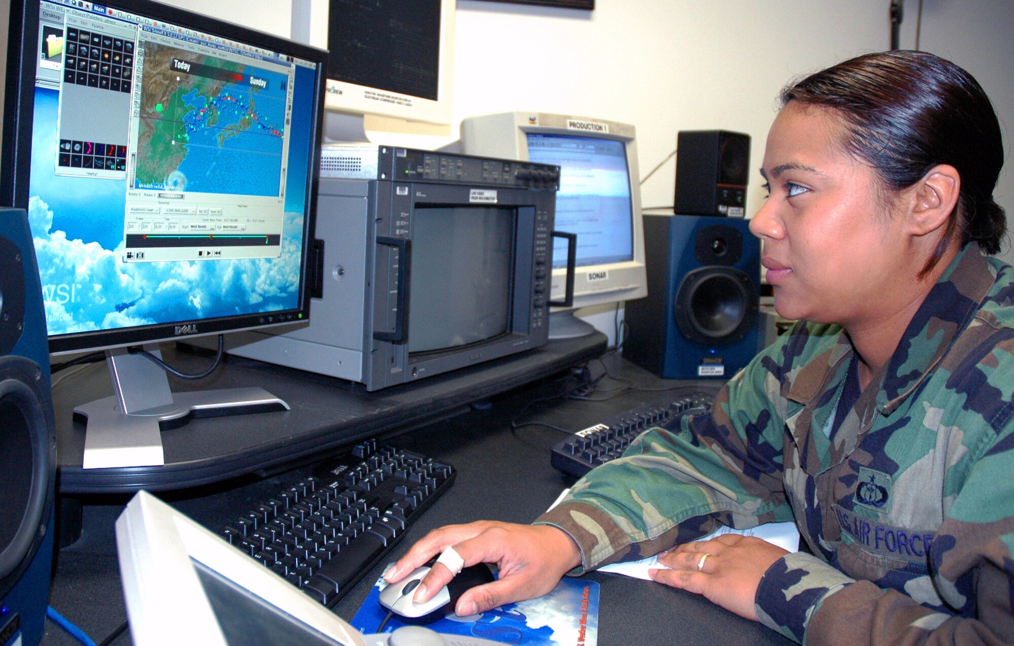 Staff Sgt. Annette Prato, a broadcast weather technician at the American Forces Network Weather Center at Offutt Air Force Base, Neb., uses the center's new production system to create visuals for their Pacific weather forecast.  The weather center produces 10 shows a day, each disseminated worldwide via satellite. (U.S. Air Force photo/G. A. Volb)