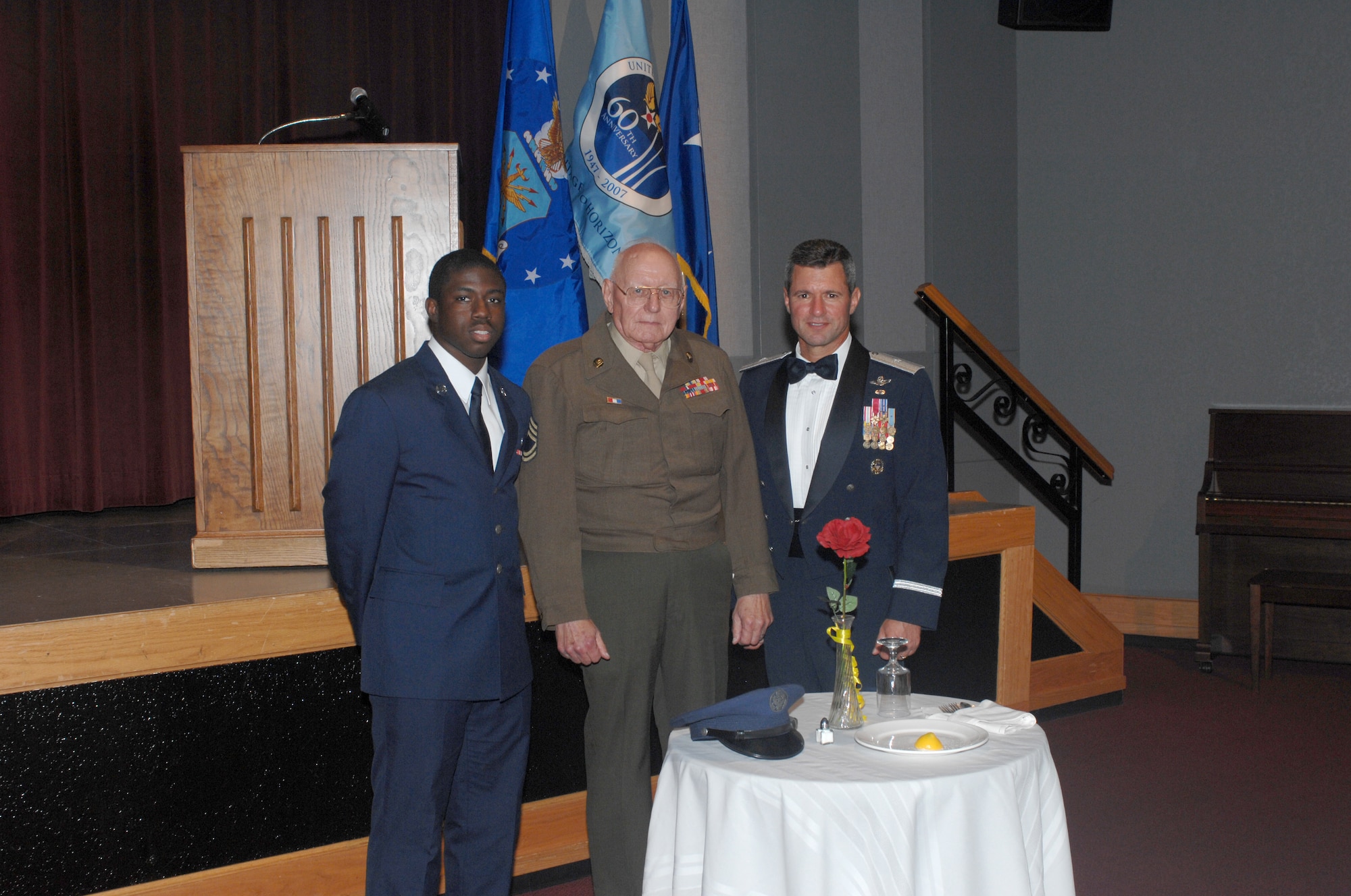 WHITEMAN AIR FORCE BASE, Mo. -- Left to right: Airman Basic James Williams, 509th Medical Support Squadron, retired Chief Master Sgt. Mel Bockelman and Brig. Gen. Greg Biscone, 509th Bomb Wing commander, stand beside the Prisoner of War/Missing In Action table at the Air Force Ball Aug. 18. Chief Bockelman is wearing his Army Air Corps Class “A” uniform with the Eisenhower battle jacket, which was designed by Gen. Dwight D. Eisenhower during World War II.This year’s ball commemorated the Air Force’s 60th Anniversary, and was held at Elliott Union on the University of Central Missouri campus. (U.S. Air Force photo/Tech. Sgt. Samuel Park)
