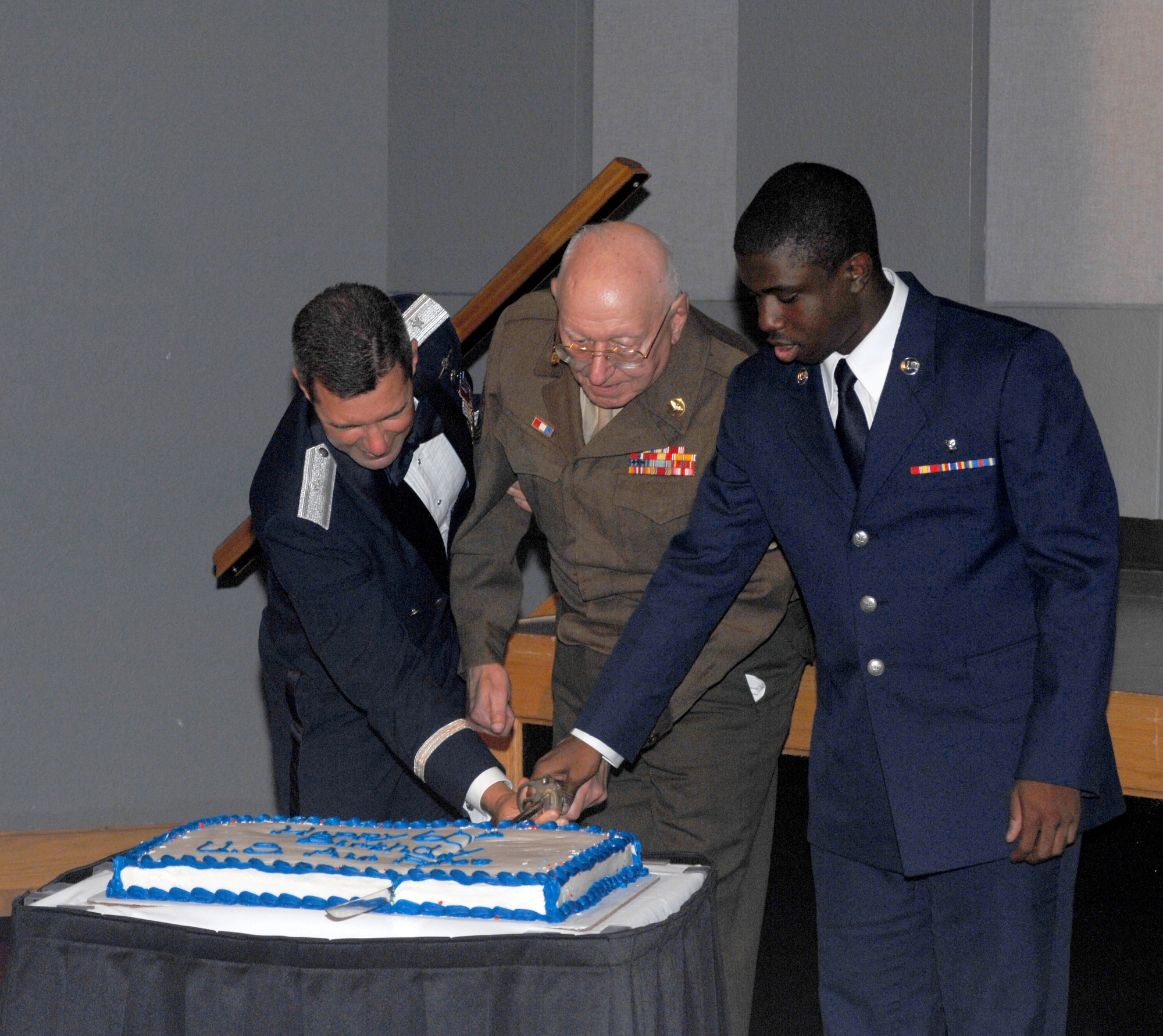 WHITEMAN AIR FORCE BASE, Mo. -- Left to right: Brig. Gen. Greg Biscone, 509th Bomb Wing commander, retired Chief Master Sgt. Mel Bockelman and Airman Basic James Williams, 509th Medical Support Squadron, cut the cake at the Air Force Ball Aug. 18. It is an Air Force tradition to have the most senior ranking Airman and the youngest Airman cut the cake. Chief Bockelman is wearing his Army Air Corps Class “A” uniform with the Eisenhower battle jacket, which was designed by Gen. Dwight D. Eisenhower during World War II. This year’s ball commemorated the Air Force’s 60th Anniversary, and was held at Elliott Union on the University of Central Missouri campus. (U.S. Air Force photo/Tech. Sgt. Samuel Park)