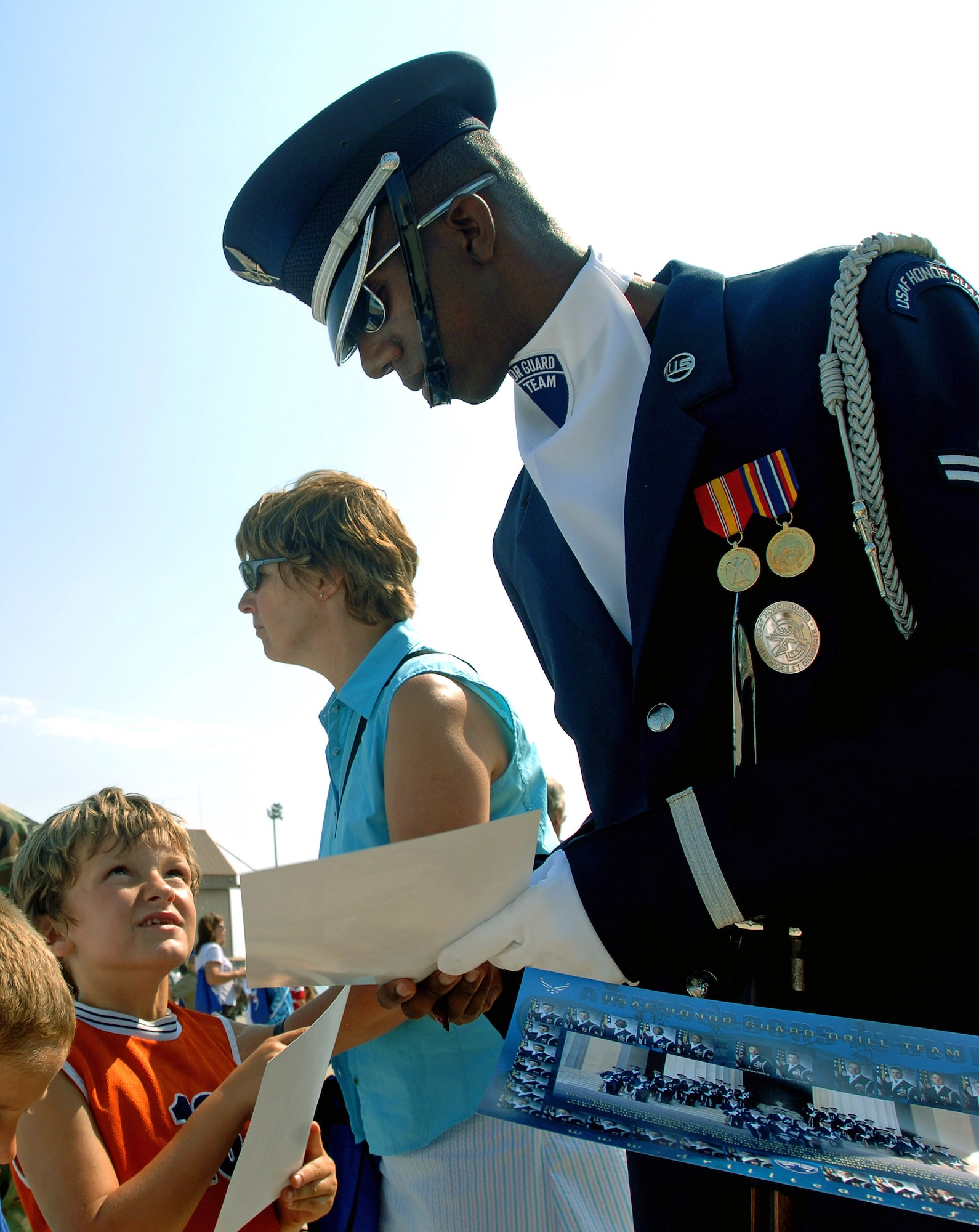 Airman 1st Class Alexander Tonic of the U.S. Air Force Honor Guard Drill Team signs autographs after a performance for children with special needs Aug. 17 at Pease Air National Guard Base, N.H. The drill team's performance was part of the 2007 Wings of Hope Air Show at Pease in conjunction with Air Force Week New England. (U.S. Air Force photo/Staff Sgt. Bennie J. Davis III) 

