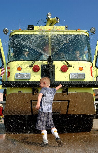 Seven-year-old Teagan from Portsmouth, N.H., leaves his wheelchair behind and dances with the help of leg braces in water sprayed from a fire truck Aug. 17 at the 2007 Wings of Hope Air Show for children with special needs at Pease Air National Guard Base, N.H. The Portsmouth Fire Department truck was on display at the air show, held in conjunction with Air Force Week New England. (U.S. Air Force photo/Staff Sgt. Bennie J. Davis III) 
