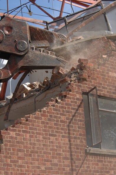 Bearing a striking resemblance to a dinosaur head, the shear of the excavator being used to demolish Building 402 at RAF Mildenhall, has the ability to exert 28,000 pounds per square inch of pressure. With this level of strength, the brick walls crumble as if they're made of cardboard.  (U.S. Air Force photo by Tech. Sgt. Tracy L. DeMarco)