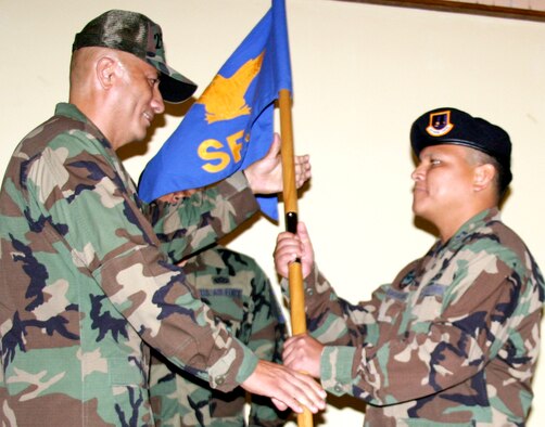 ANDERSEN AIR FORCE BASE, Guam - Capt. Joseph Pangelinan takes the guidon 254th Security Forces Squadron guidon from Col. James Montague, 254th Air Base Group commander, during his change of command ceremony.  Captain Pangelinan became commander of the 254th SFS in a change of command ceremony held Aug. 11 at the Oceanview Conference Center.  (Photo by Senior Airman Christine Martinez/Guam Air National Guard)