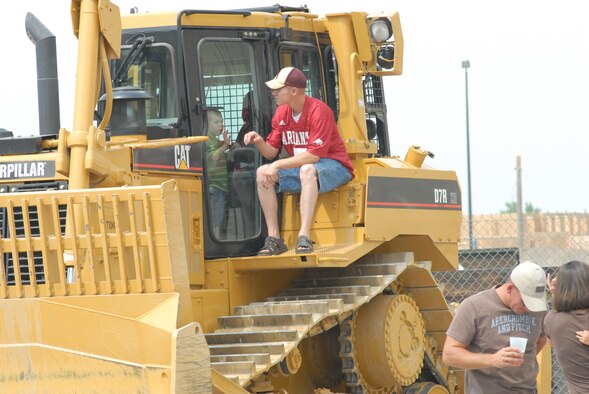 Staff Sgt. John Bolls and his son Zach, 3, explore a bulldozer during the 819th RED HORSE Squadron's 10th anniversary celebration Aug. 17. The squadron hosted a variety of commemorative events Aug. 15 to 18 at Malmstrom Air Force Base, Mont. (U.S. Air Force photo/John Turner).