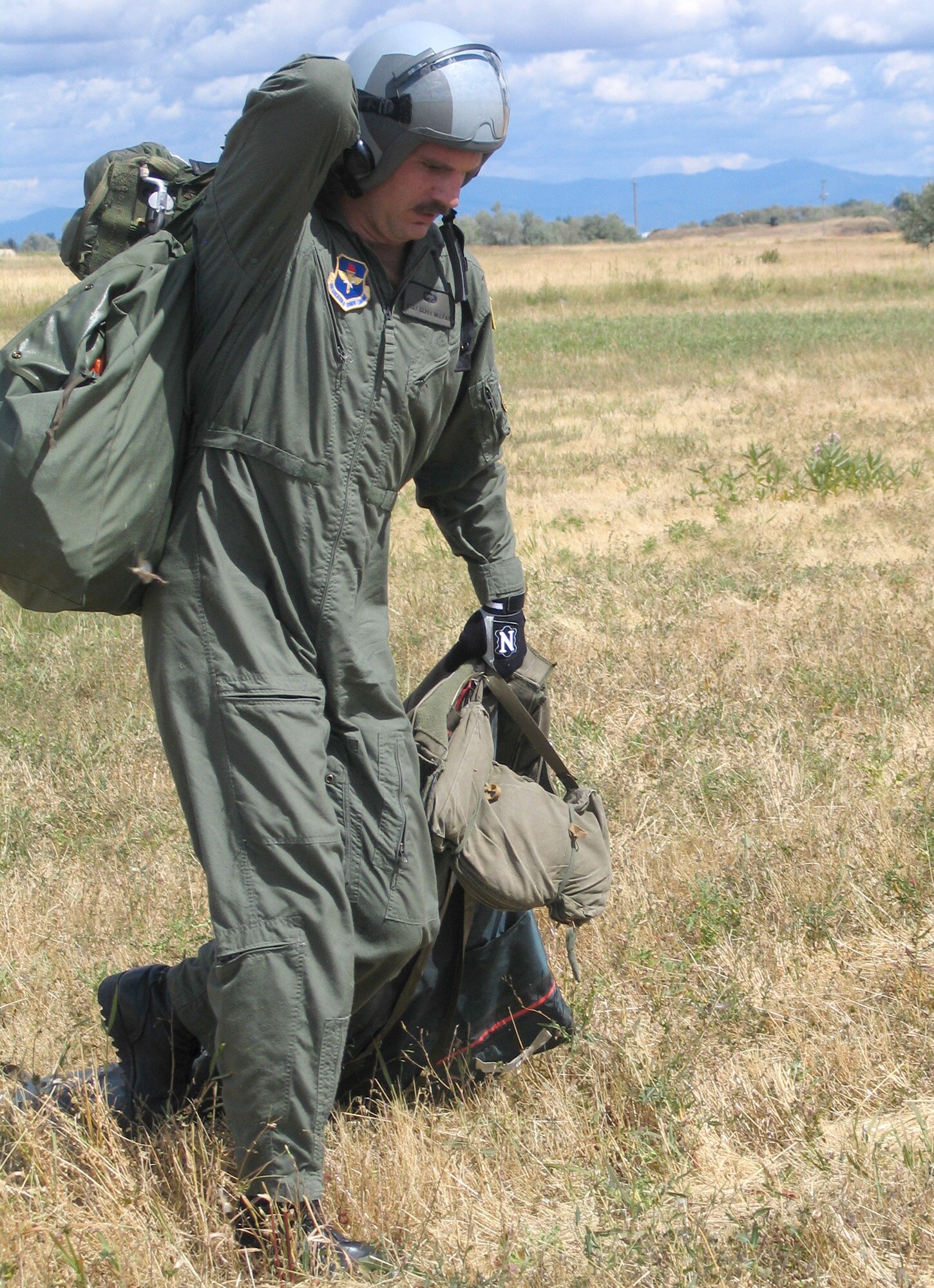 FAIRCHILD AIR FORCE BASE, Wash. – Staff Sgt. Gary McLean, a Survival, Evasion, Resistance and Escape school instructor with the 22nd Training Squadron here, carries his packed parachute out of a field after jumping from a UH-1 Huey Aug. 21, during a jump demonstration for SERE students. Sergeant McClean was one member of a four-man SERE school parachute team that placed fourth in the annual international parachute competition this month, Leapfest 2007. This is the first year Fairchild has participated in Leapfest since 2003. (U.S. Air Force photo / Staff Sgt. Connie L. Bias)