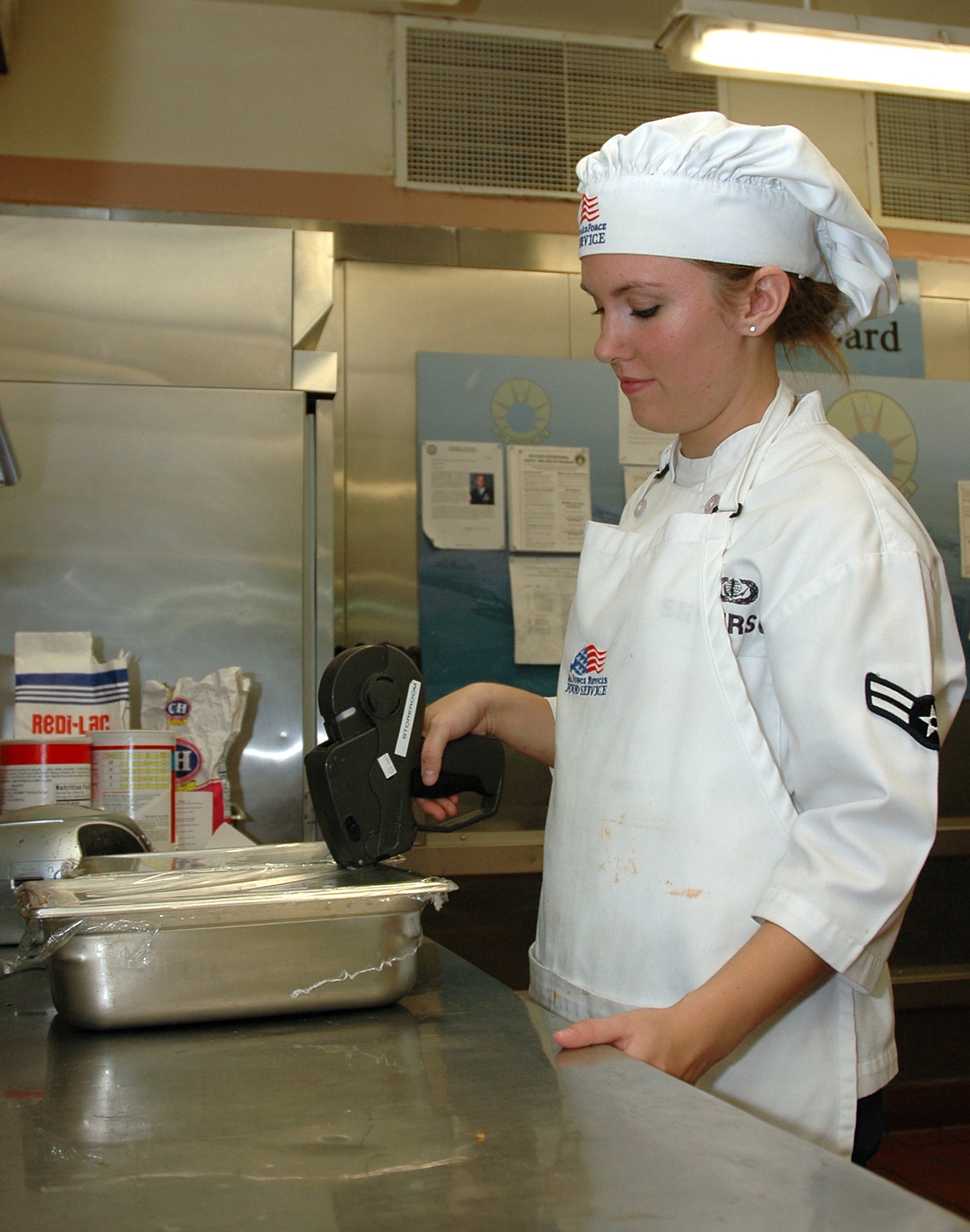 MOUNTAIN HOME AIR FORCE BASE, Idaho -- Airman 1st Class April L. Severson, a food service apprentice at the Wagon Wheel dining facility here, uses date and time labels to mark food prepared at the facility Aug. 20.  The Wagon Wheel was selected, along with the Trailwinds Flight Kitchen, to represent Air Combat Command in the 2008 John L. Hennessy Trophy competition. (U.S. Air Force photo/ Staff Sgt. Rodney D. Ivey)