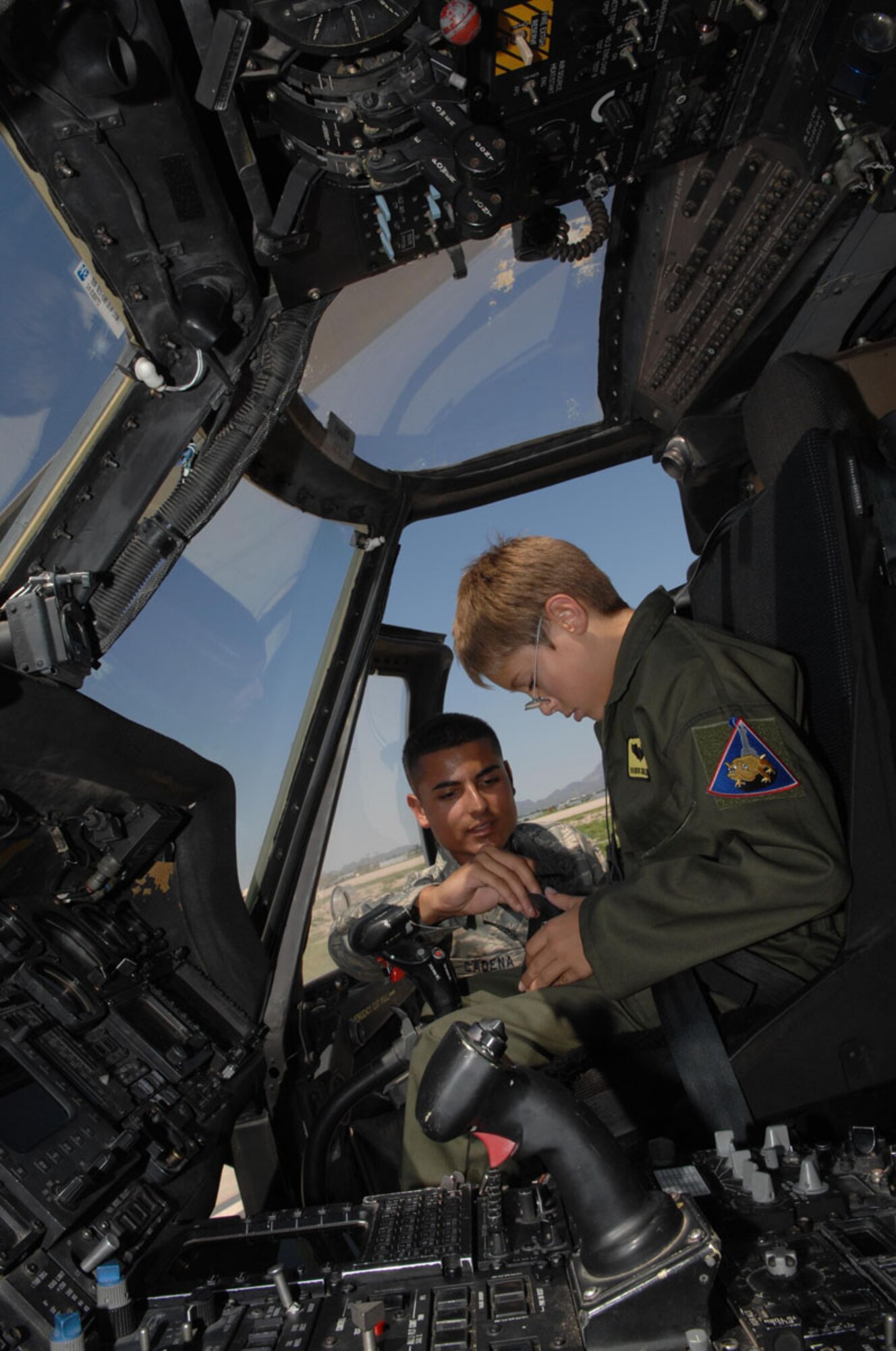 Airman 1st Class Mark Cadena, 563rd Maintenance Squadron, shows 10-year-old Brandon Smalling the different aspects of a HH-60 Pavehawk, Thursday August 10 at Davis-Monthan AFB, Ariz as part of the Pilot for a Day program. The program is designed to help children with disabilities or serious illnesses to enjoy a day focused on them and their interest in aviation. Activities in the program include; trying on life support equipment, using Night Vision goggles, flying an A-10 simulator, and seeing aircraft up close.(U.S. Air Force photo/Senior Airman Christina D. Kinsey)