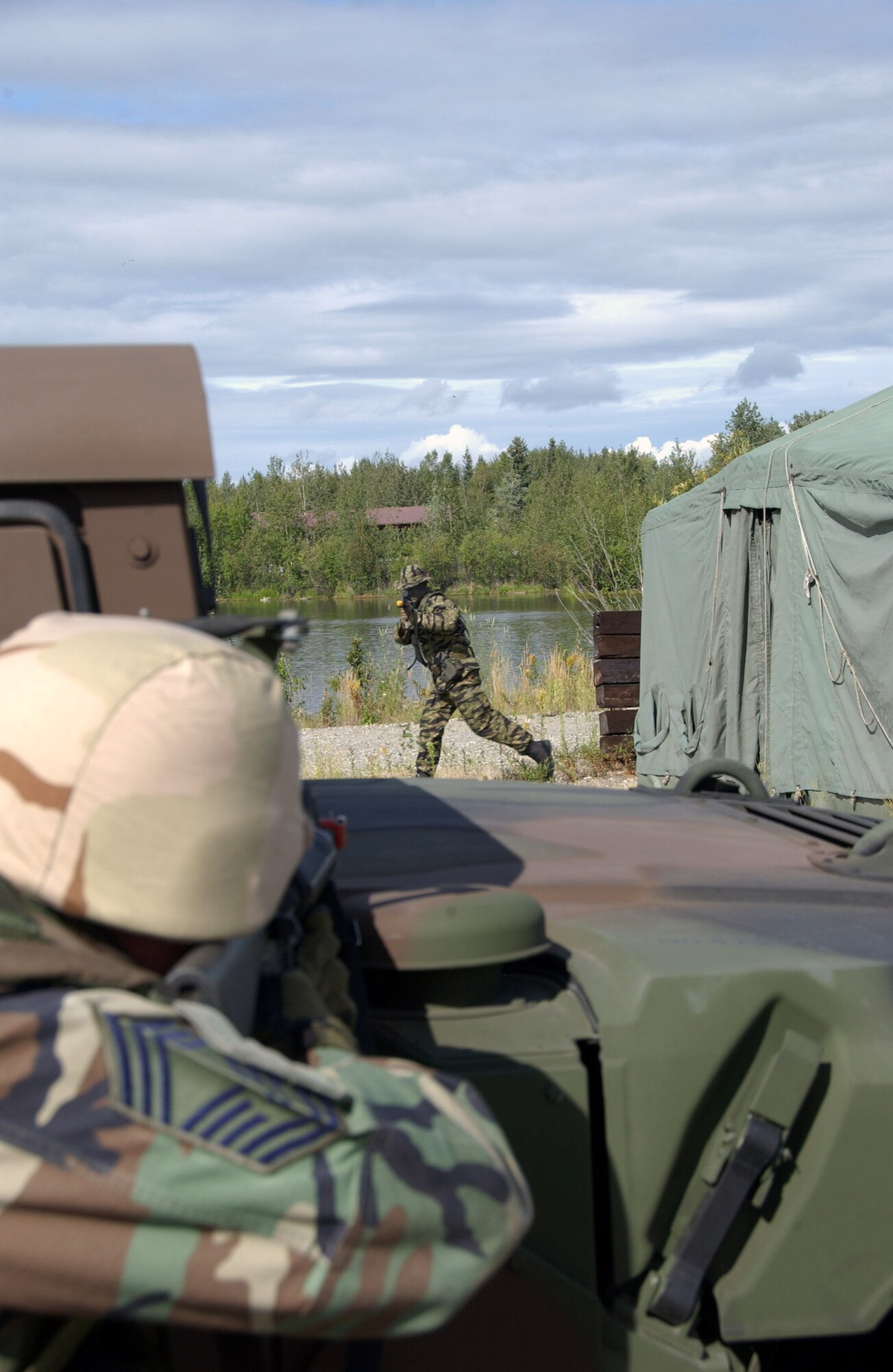 Chief Master Sgt. Matthew Marshall fires at an "enemy" from behind a Humvee during combat skills training Aug. 3 at Eielson Air Force Base, Alaska. This training gives Airmen the skills necessary to perform and adapt in a combat environment while deployed. Chief Marshall is assigned to the 354th Logistics Readiness Squadron. (U.S. Air Force photo/Airman 1st Class Christopher Griffin)
