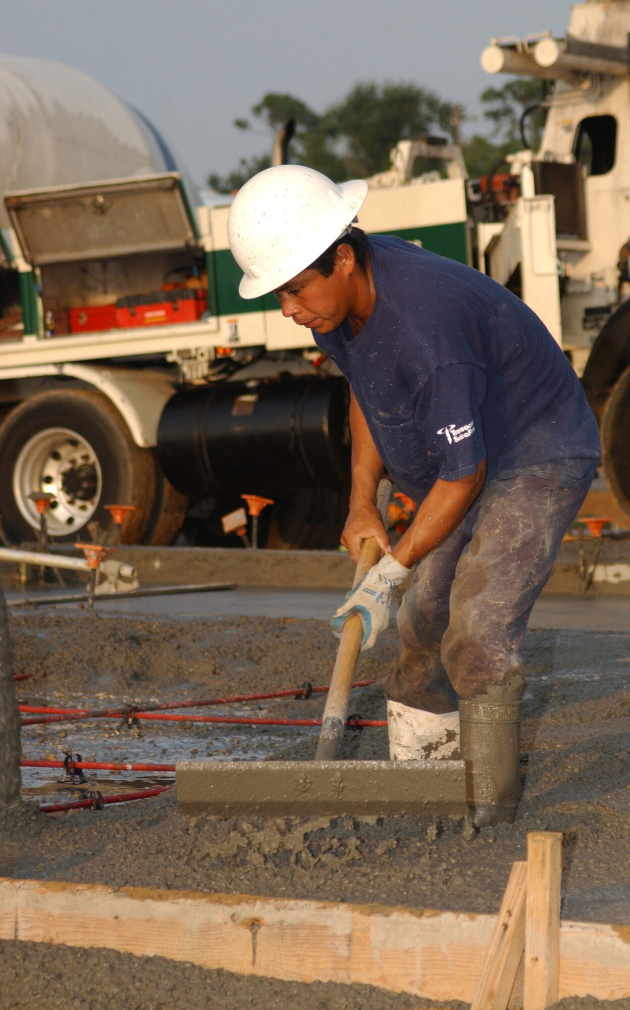 Contractor Apoliwar Zamora smooths a slab for a new home in Thrower Park,  where walls went up Wednesday in for the first unit in the largest military family housing project in Air Force history.   The $287.8 million program is building 1,028 new homes for Keesler families.  (U.S. Air Force photo by Kemberly Groue)
