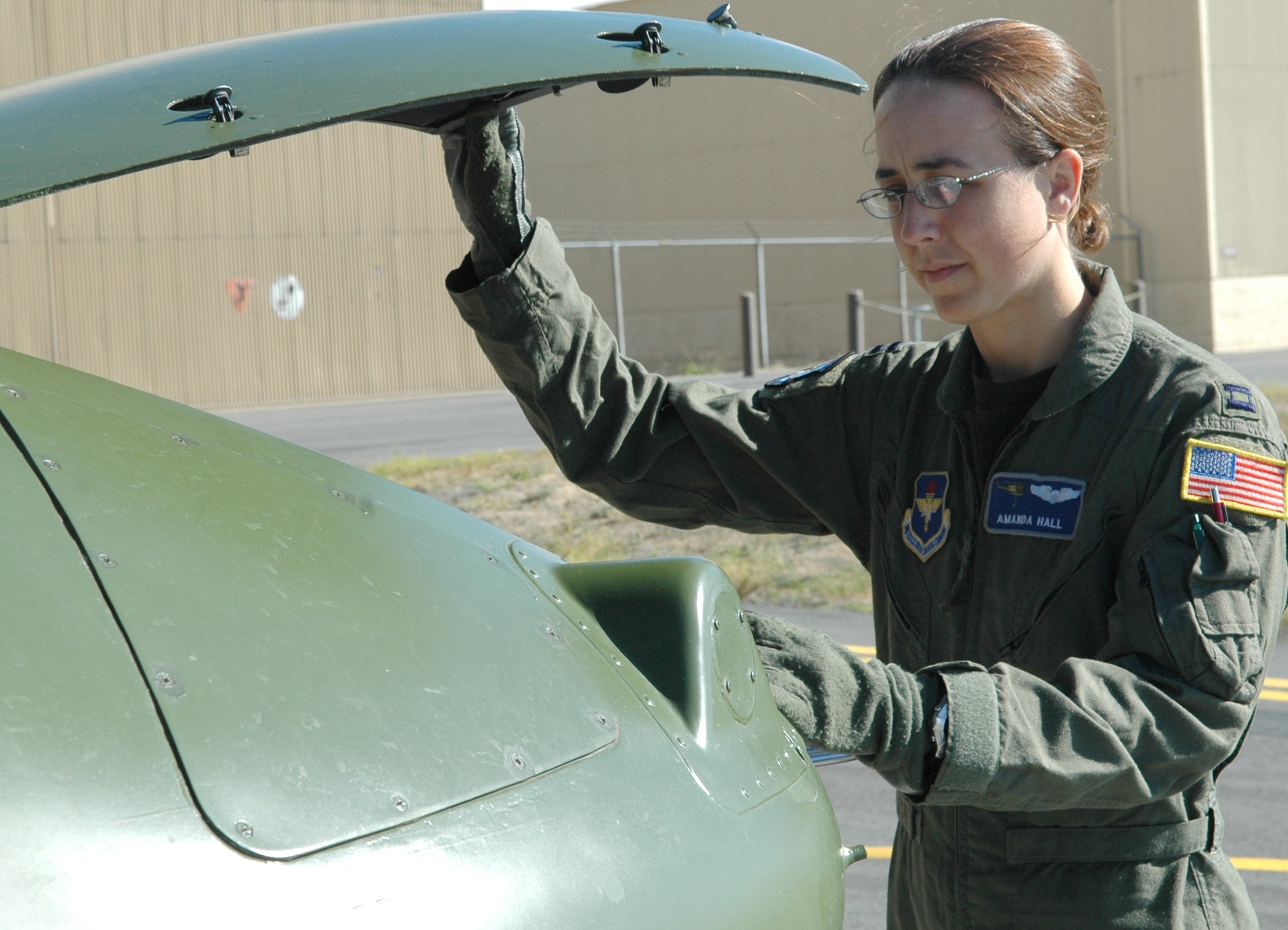 FAIRCHILD AIR FORCE BASE, Wash. -- Capt. Amanda Hall, 36th Rescue Flight UH-1N Huey evaluator pilot, inspects the electronic equipment in the nose of the aircraft during pre-flight checks on the tarmac here. When the hoist is going to be used during a mission, the flight engineer must inspect it so the pilot/co-pilot assist with the some of the pre-flight checks.(U.S. Air Force Photo / Tech. Sgt. Larry W. Carpenter Jr.)