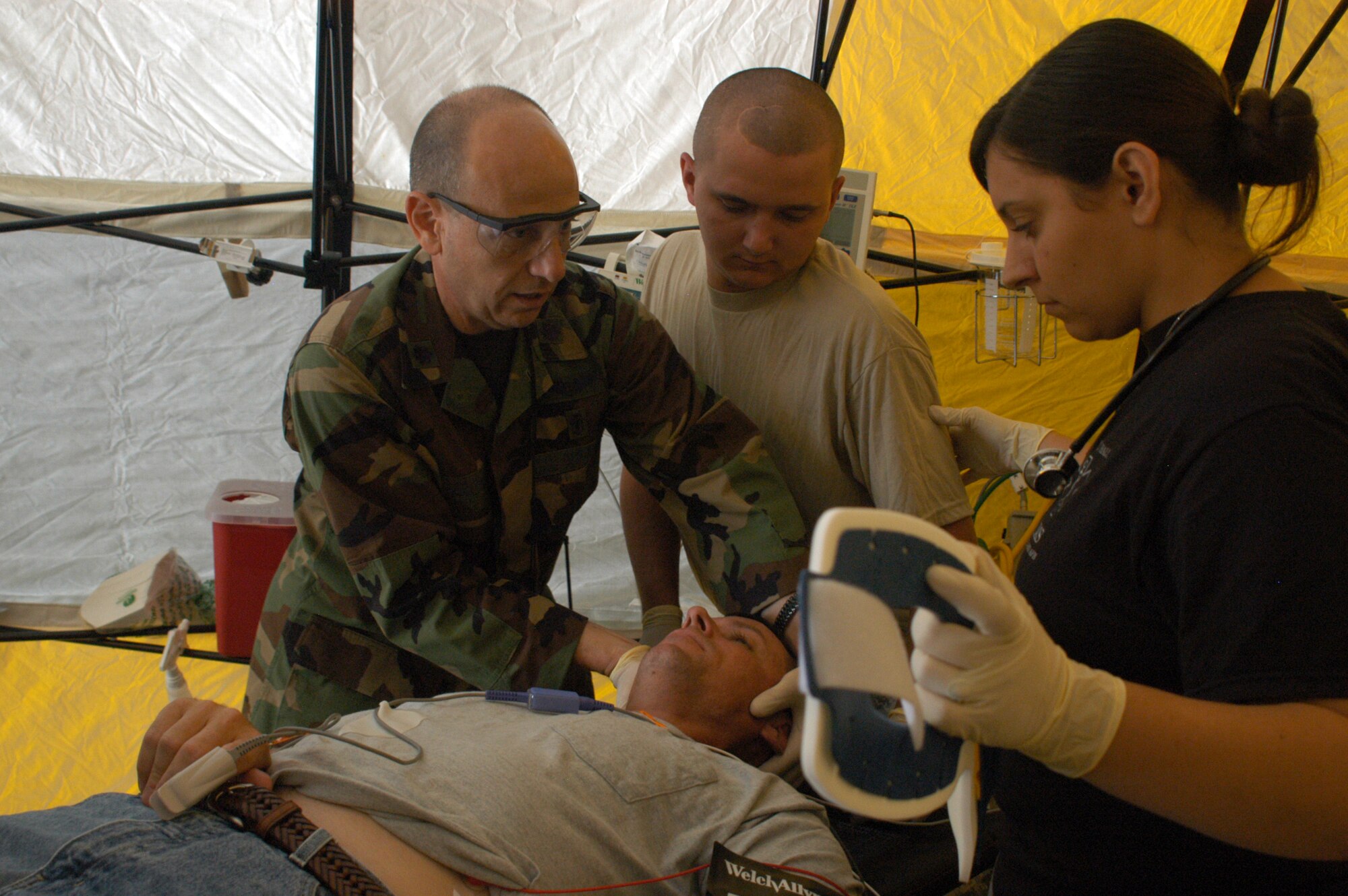 Lt. Col. Louis Perino and Senior Airman Kristen Gault, 116th Medical Group, along with Spc. Tommy Turner of the JTF 781st work along side in a joint effort to access the condition of a patient during a medical training exercise at Robins Air Force Base, Aug. 17. (Photo by Tech. Sgt. Tim Neville)