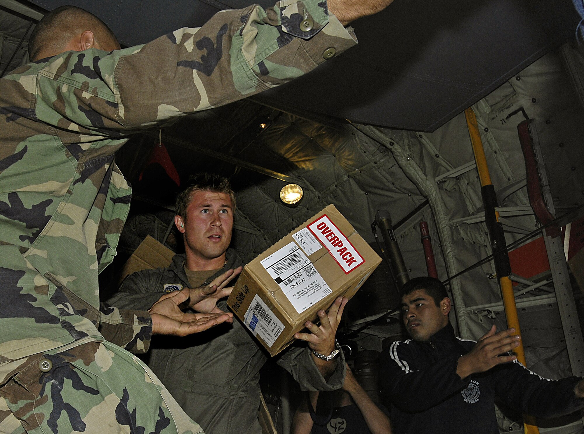 Capt. Bart Robinson and Peruvian aid workers unload supplies from a C-130 Hercules Aug. 19 in Pisco, Peru. The supplies are for the victims of an 8.0 magnitude earthquake that hit parts of western Peru. Around 80,000 Peruvians have been affected by the earthquake, and 80 percent of the homes were destroyed in the city of Pisco. Captain Robinson is with the Maryland Air National Guard. (U.S. Air Force photo/Staff Sgt Richard Rose)
