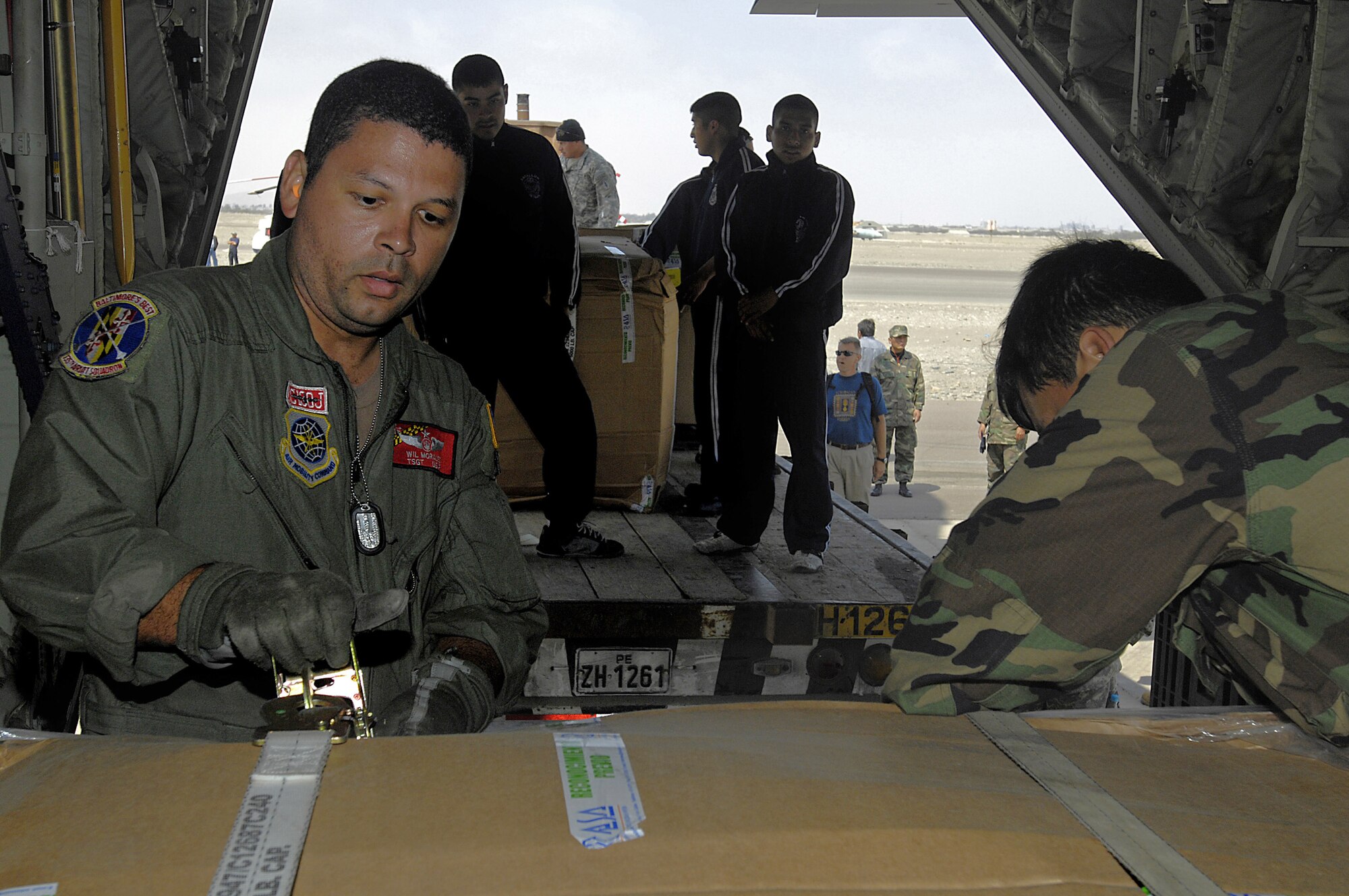 Tech. Sgt. Wilbert Morales and Peruvian aid workers unload supplies from a C-130 Hercules aircraft Aug. 19 in Pisco, Peru. The supplies are for the victims of an 8.0 magnitude earthquake that hit parts of western Peru. Around 80,000 Peruvians have been affected by the earthquake, and 80 percent of the homes were destroyed in the city of Pisco. Sergeant Morales is with the Maryland Air National Guard. (U.S. Air Force photo/Staff Sgt. Richard Rose)
