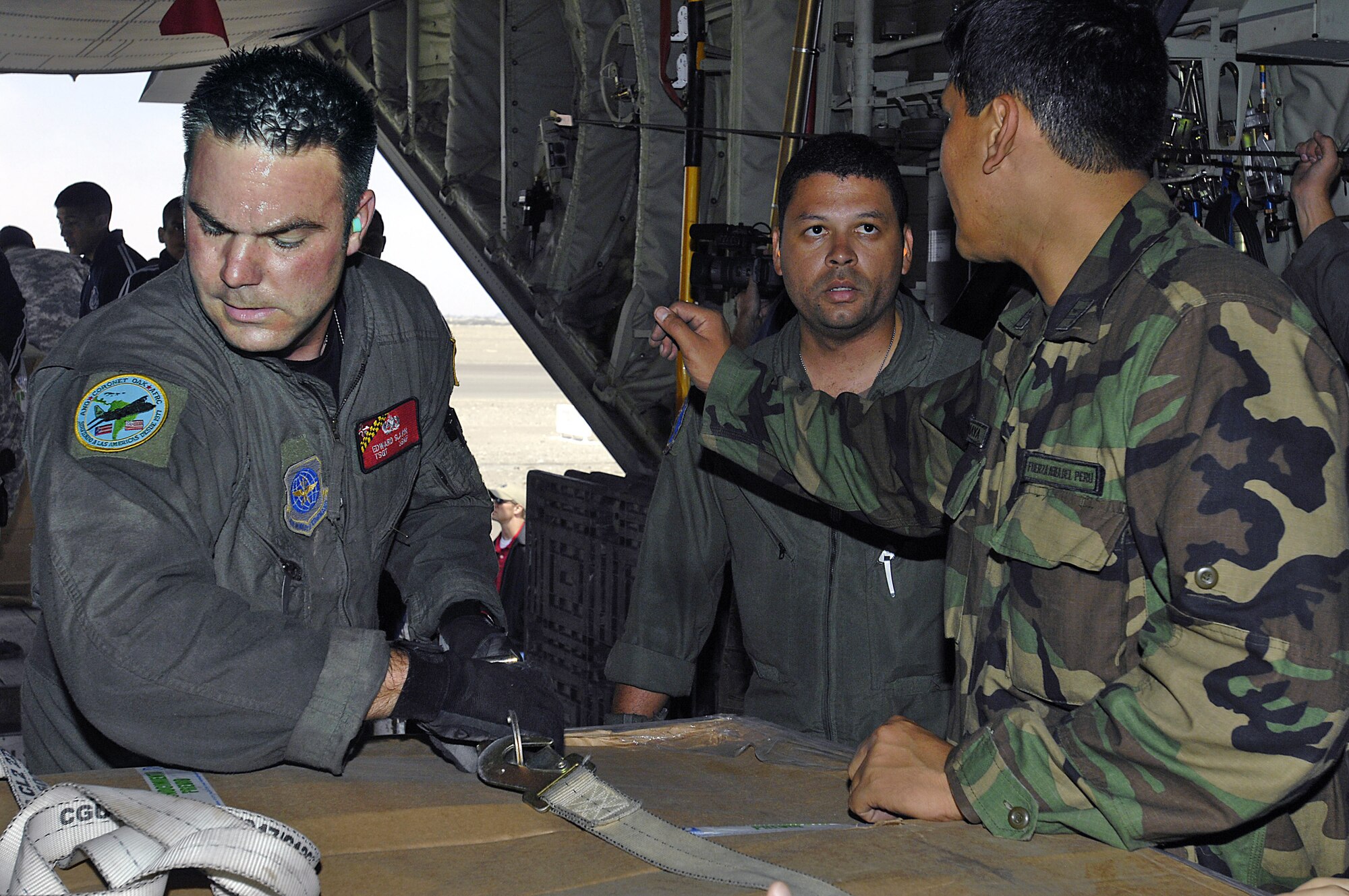 Technical Sergeants Edward Slavin (left) and Wilbert Morales and Peruvian aid workers unload supplies from a C-130 Hercules in Pisco, Peru, Aug. 19. The supplies are for the victims of an 8.0 magnitude earthquake that hit parts of western Peru. Around 80,000 Peruvians have been affected by the earthquake, and 80 percent of the homes were destroyed in the city of Pisco. The sergeants are both from the Maryland Air National Guard. (U.S. Air Force photo/Staff Sgt. Richard Rose) 

