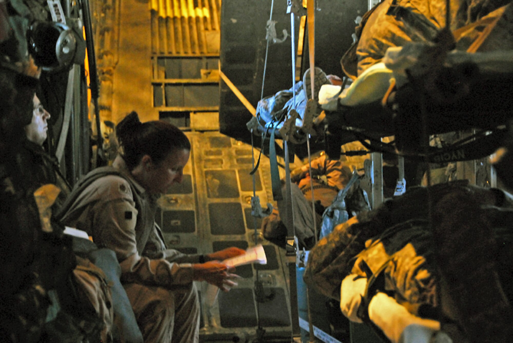 Maj. Beth Ann Gambill reviews medical charts of wounded Airmen and Soldiers picked up from Iraq in a C-130 Hercules Aug. 18 during an aeromedical evacuation mission.  Major Gambill is the deputy chief of the Aeromedical Evacuation Control Team.  (U.S. Air Force photo/Tech. Sgt. Scott Moorman)