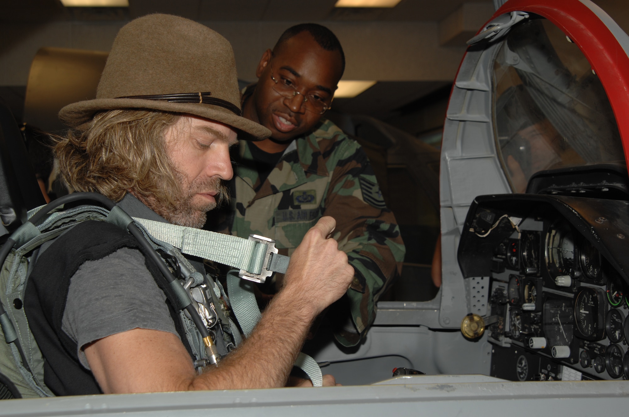 WHITEMAN AIR FORCE BASE, Mo. – Left to right: Country music performer "Big Kenny," part of the duo who make up Big & Rich, sits in a T-38 trainer while Tech. Sgt. Victor Ware, 509th Operations Support Squadron assists him Aug. 16. The Big & Rich members, who have demonstrated their support for the military at numerous public concerts and events, got a chance to say “Thank you,” to troops and recognize them for their service during a forum in the roll call room. (U.S. Air Force photo/Senior Airman Lauren Padden)   
