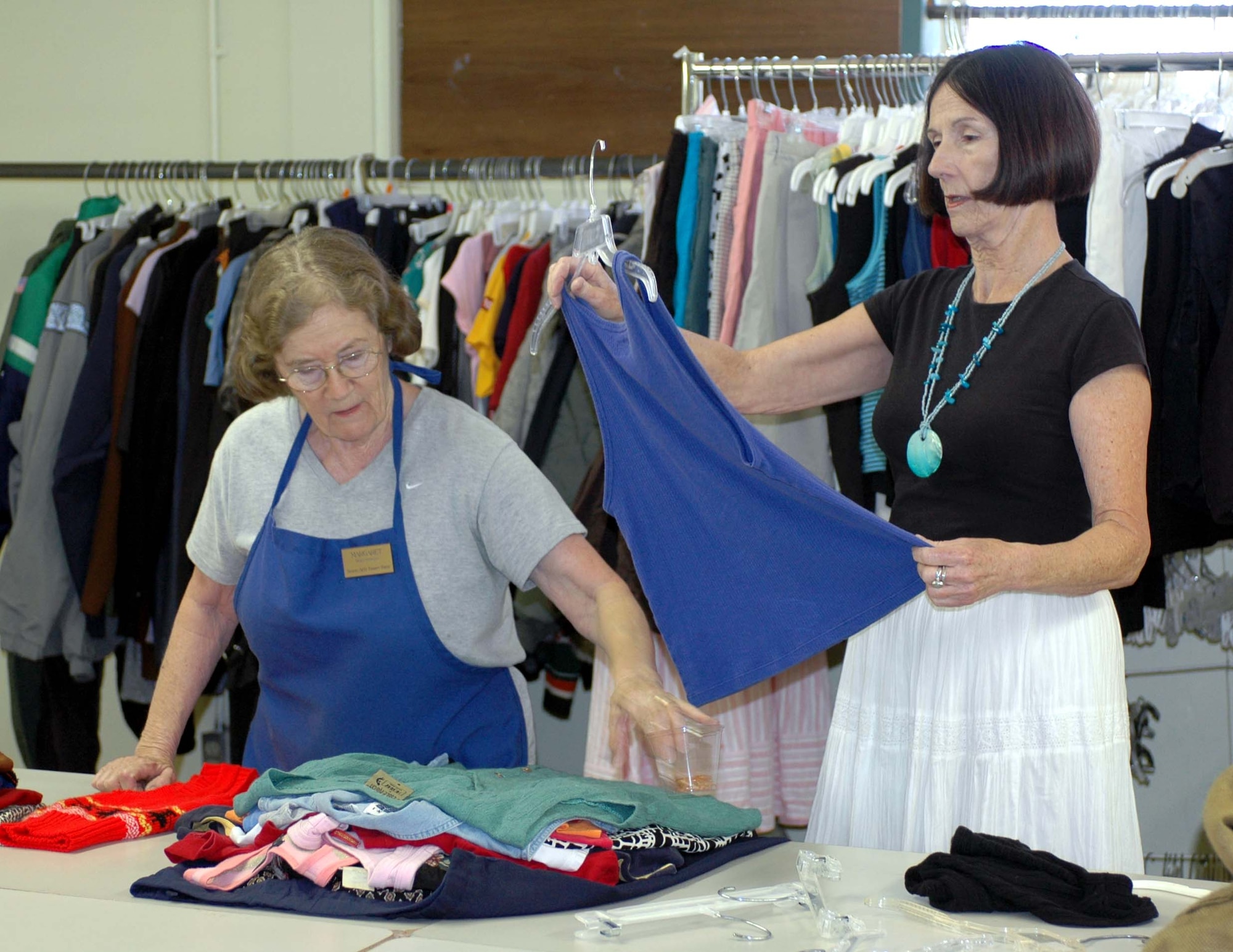Volunteers Margaret Wheeler and Lois Horner sort donated shirts at the Thrift Shop. The shop relies on donations from servicemembers and their families. (U.S. Air Force photo/ Nick DeCicco)