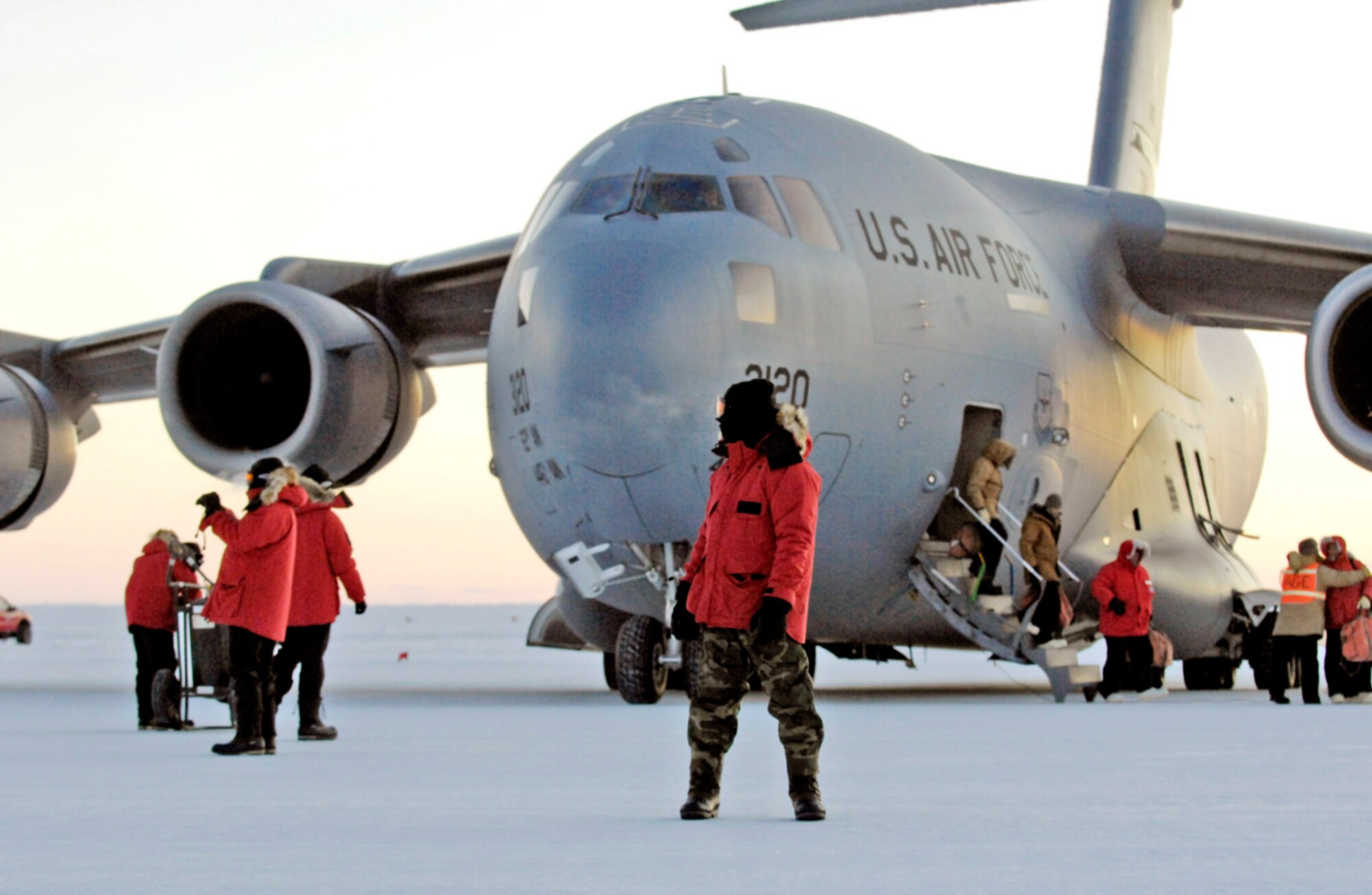 A maintainer looks as National Science Foundation Members get off a C-17 Globemaster III during the Operation Deep Freeze winter fly-in around the Pegasus Runway Aug. 20 in Antarctica. A C-17 and 31 Airmen from McChord Air Force Base, Wash., began the annual winter fly-in augmentation of scientists, support personnel, food and equipment for the U.S. Antarctic Program at McMurdo Station. WinFly is the opening of the first flights to McMurdo Station, which closed for the austral winter in February. (U.S. Air Force photo/Tech. Sgt. Shane A. Cuomo) 