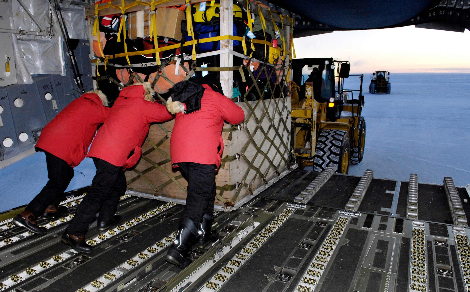 Loadmasters unload a pallet from their C-17 Globemaster III during the winter fly-in for Operation Deep Freeze Aug. 20 at Pegasus Runway in Antarctica. A C-17 and 31 Airmen from McChord Air Force Base, Wash., began the annual winter fly-in augmentation of scientists, support personnel, food and equipment for the U.S. Antarctic Program at McMurdo Station. WinFly is the opening of the first flights to McMurdo Station, which closed for the austral winter in February. (U.S. Air Force photo/Tech. Sgt. Shane A. Cuomo) 