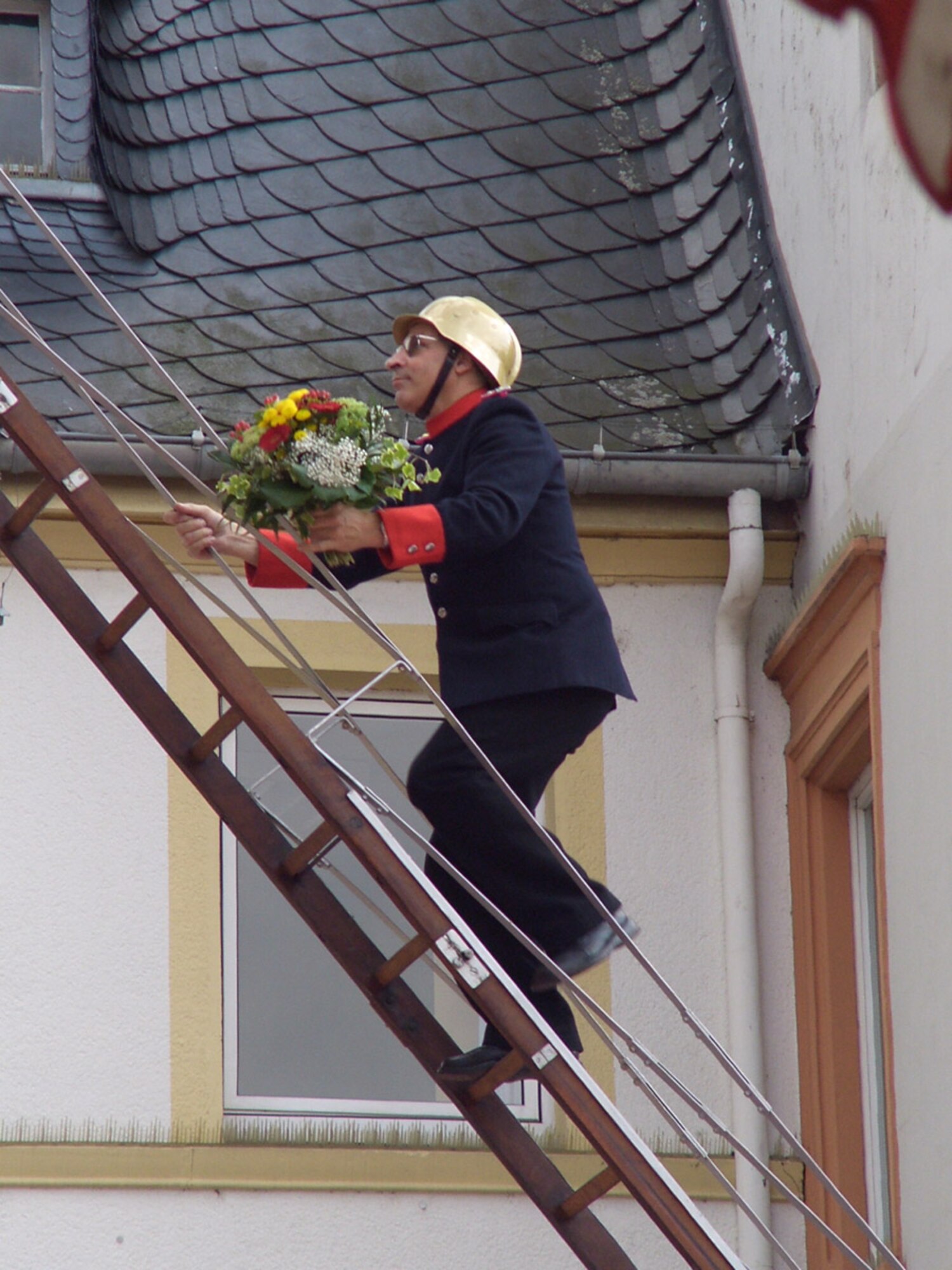 SPANGDAHLEM AIR BASE, Germany – After the Pig Fest parade that bring in the first pigs for roasting a firefighter climbs a ladder at the Wittlich town hall to present a bouquet to St. Rochus the town’s patron and blow the saint’s nose. The weekend fest attracts people from all over, as well as many Airmen from Spangdahlem AB. (U.S. Air Force photo/Capt. Kevin Coffman)