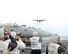 USS NIMITZ, At Sea - International media take pictures as a C-2 approaches the USS Nimitz's flight deck for landing.  Navy personnel refer to the C-2 as carrier on-board delivery, or COD. The Navy uses the COD to deliver passengers and cargo from the carrier to shore and back. The USS Nimitz was one of three aircraft carriers which participated in the exercise. (Photo by Airman 1st Class Daniel Owen/ 36th Wing Public Affairs)