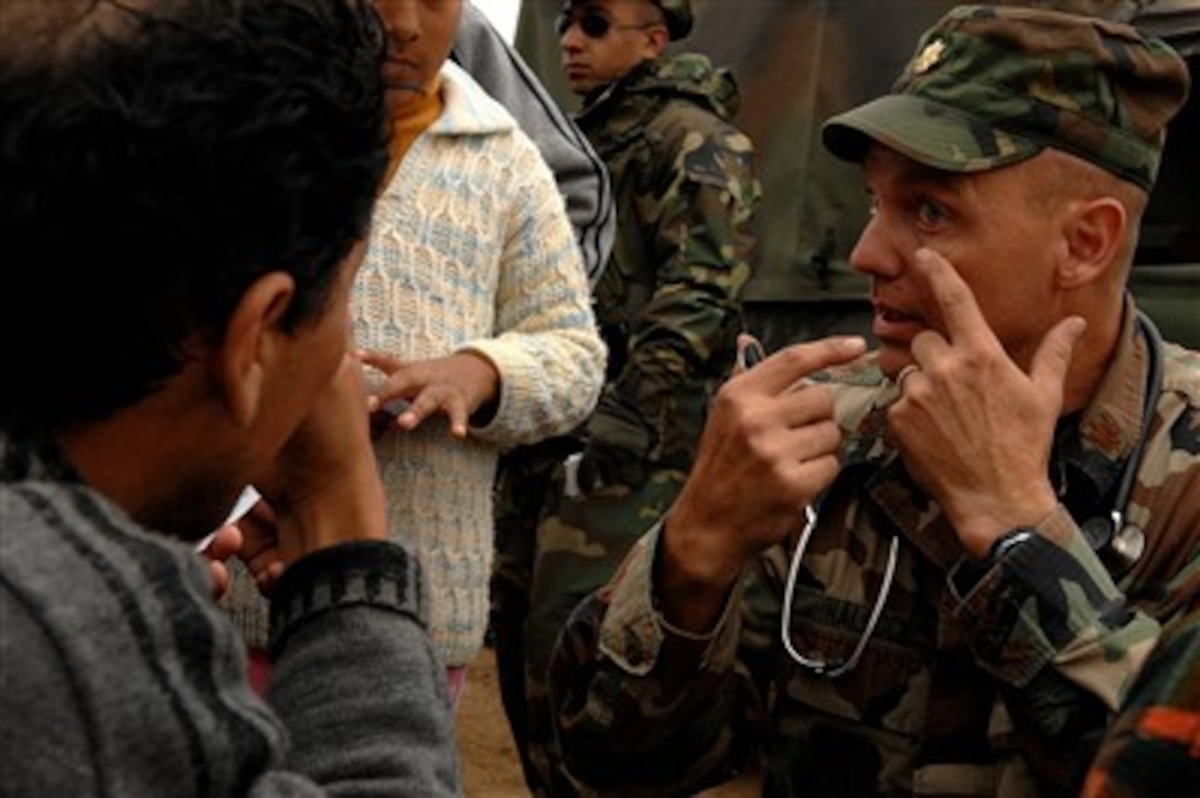 Maj. Joseph Hallock, a U.S. Air Force pediatric nurse practitioner with Joint Task Force-Bravo, gestures as he treats a young patient in Pisco, Peru, on Aug. 20, 2007.  The Department of Defense has deployed medical teams from Joint Task Force - Bravo at Soto Cano Air Base in Honduras and from Goodfellow Air Force Base in Texas to Peru to provide aid in the aftermath of an 8.0 magnitude earthquake that struck the area Aug. 15.  