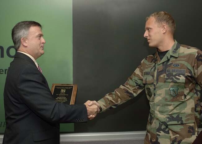 Michael Ard, Hunley Elementary school principal, presents 1st. Lt. Stephen Held, 437th Civil Engineer Squadron Network Control Center crew commander, an award for community service during the wing staff meeting Wednesday.  (U.S. Air Force Photo/Airman 1st Class Cynthia Spalding)