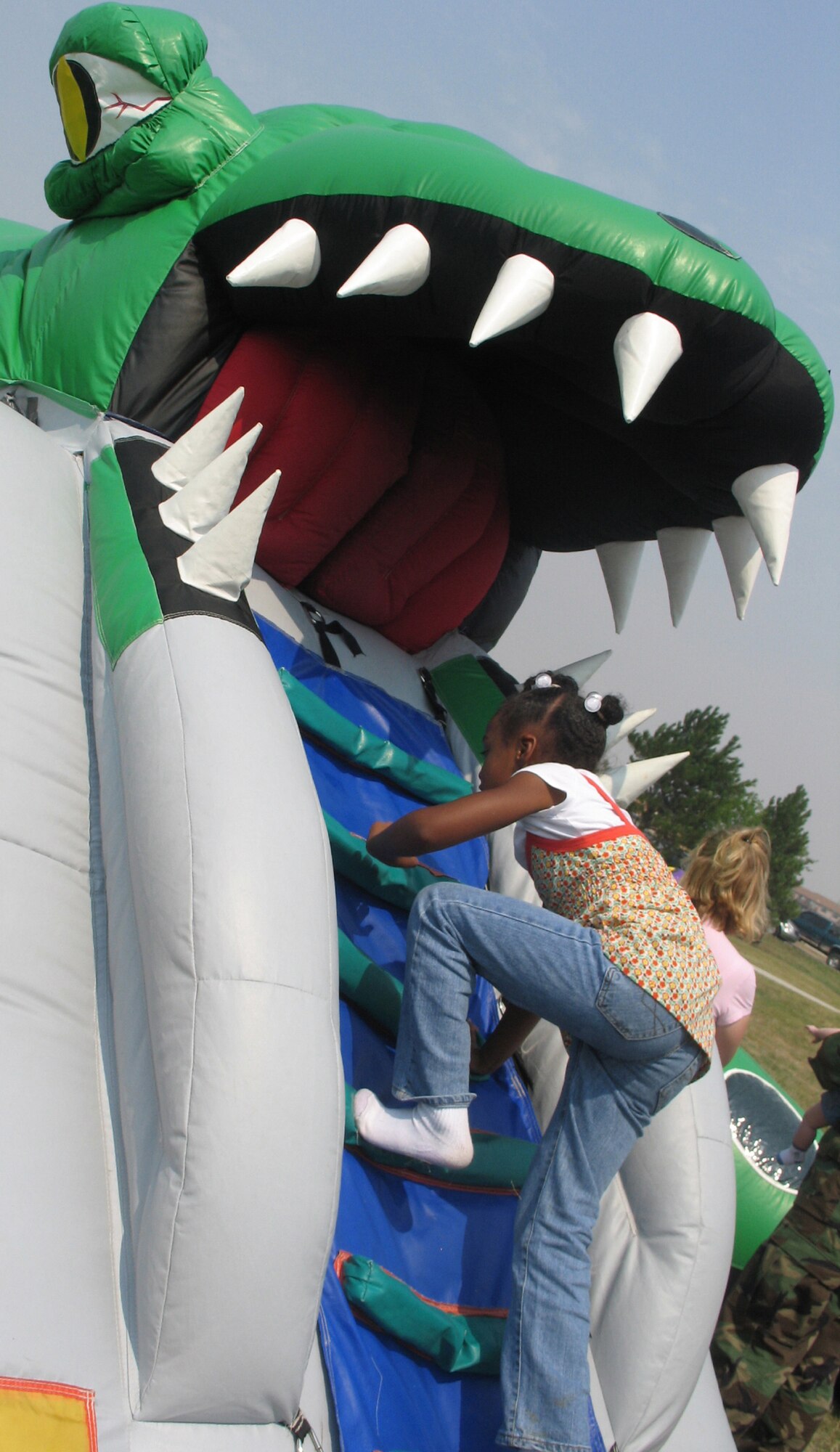The daughter of an Ellsworth Airman braves the climb into the mouth of an inflatable dragon that housed a maze of activity during the Ellsworth base picnic Aug. 20. This annual family-friendly event was sponsored primarily by local businesses as a way to say thank you to active-duty Airmen, retirees, Department of Defense civilians and families for their hard work, dedication and sacrifices. (U.S. Air Force photo/Staff Sgt. Shanda De Anda)