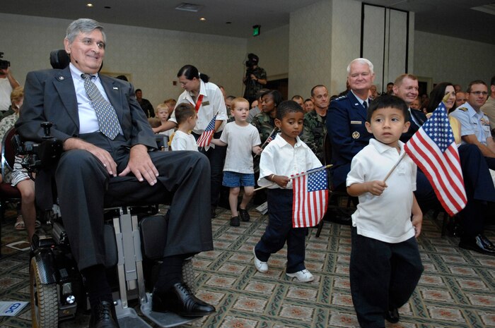 Retired Brig. Gen. Tom Mikolajcik waits as children from the child development center pass by in preparation for a song on his behalf during the dedication ceremony Aug. 17. General Mikolajcik has dedicated years of service to the Charleston AFB families. (U.S. Air Force photo/James Bowman)