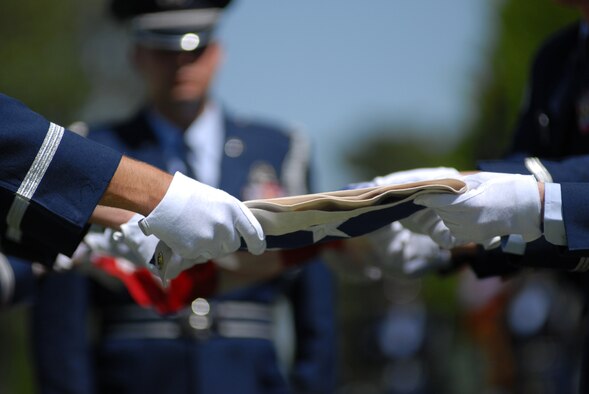 The Altus Air Force Base "Blue Knights" Honor Guard fold the flag during a funeral service honoring Lt. Col. Jim Ayres, whose remains were found more than 36 years after his jet crashed over Laos during the Vietnam era. (U.S. Air Force photo/Airman 1st Class Jennifer Flores)