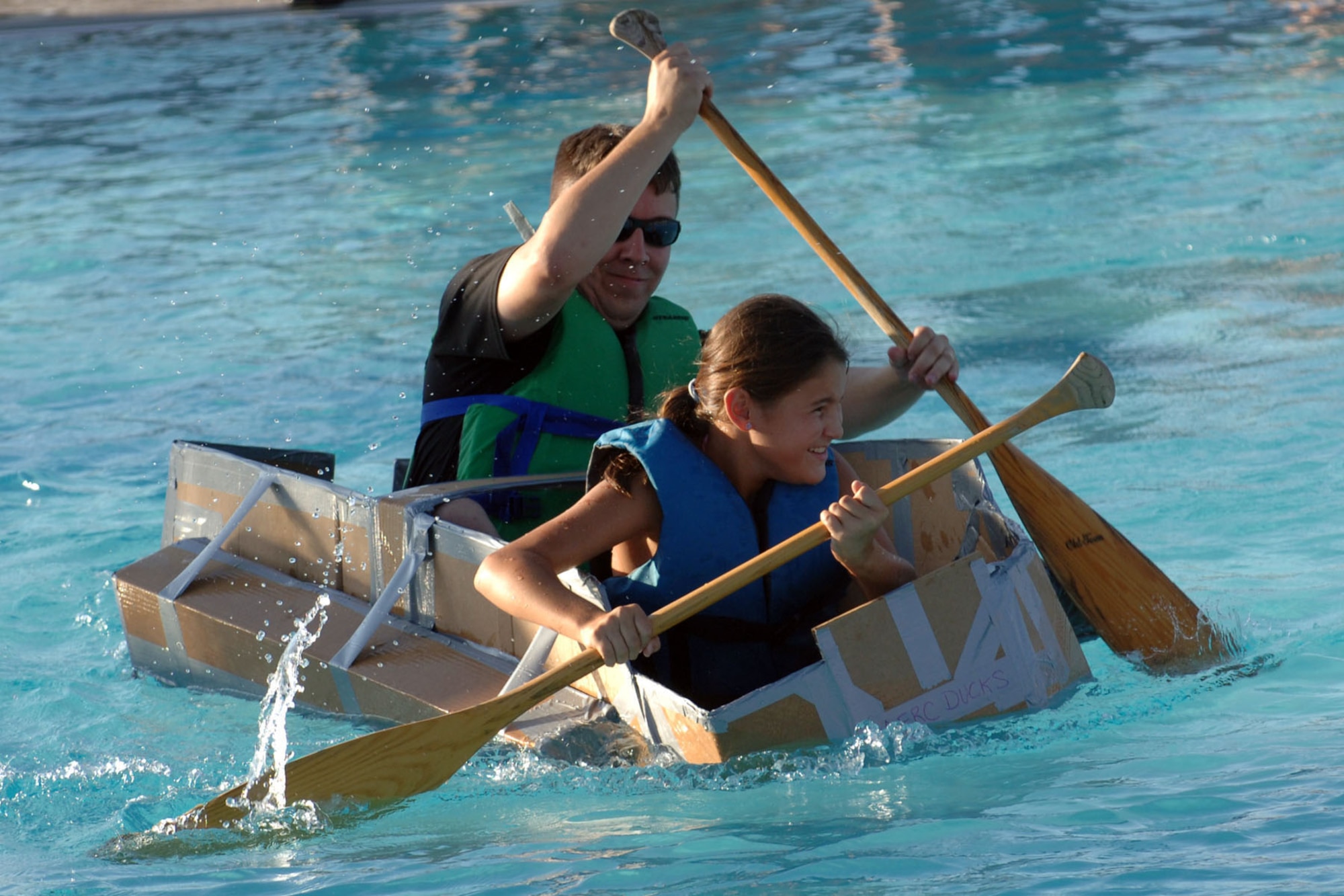 DYESS AIR FORCE BASE, Texas -- The Airman & Family Readiness Center Ducks show off their sailing skills at the base pool during Build-a-Boat Aug. 21. The Ducks' idea to use pontoons paid off when they kept their boat afloat. (U.S. Air Force Photo by Airman First Class Micheal S. Breaux)
