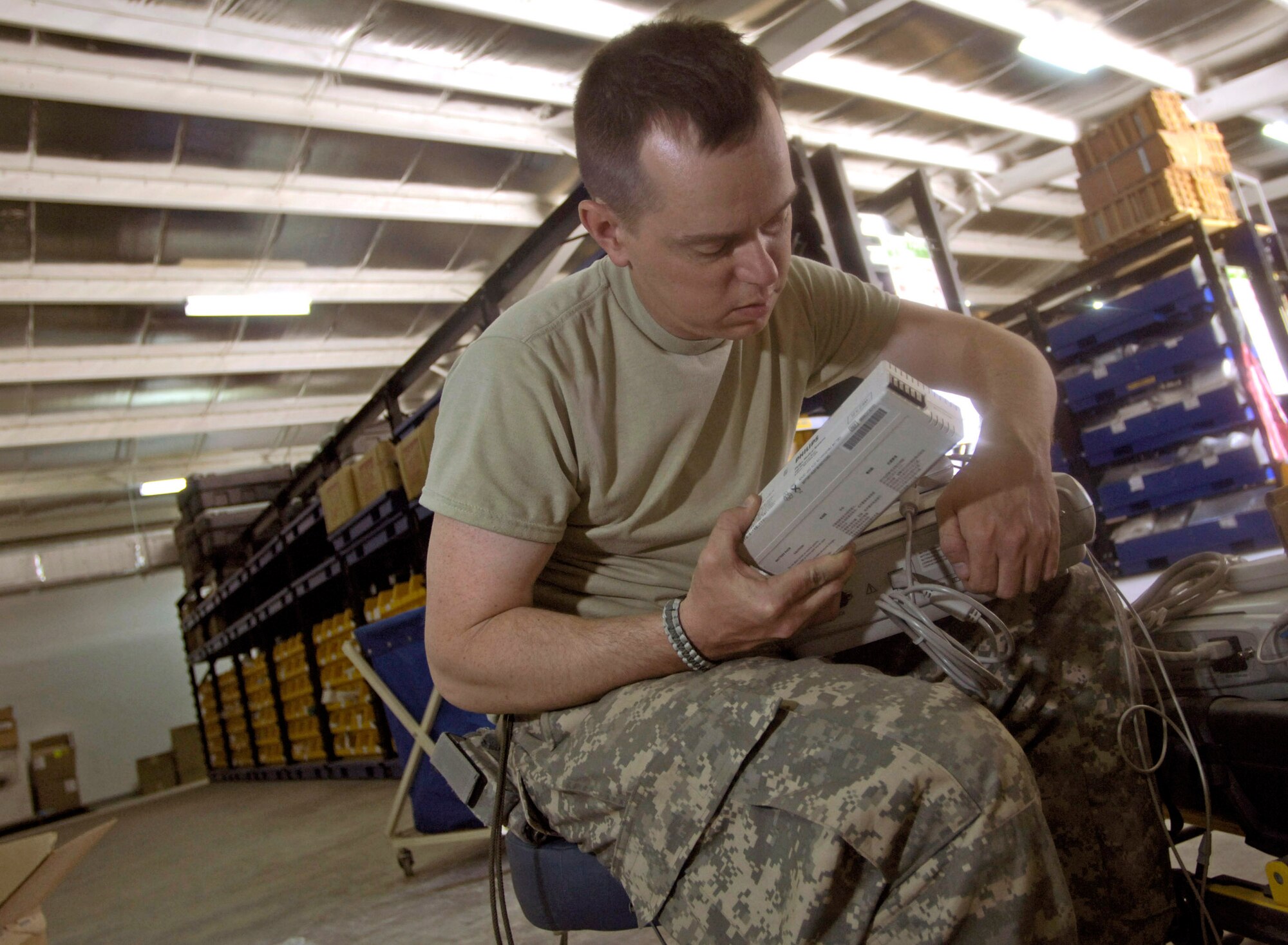 Tech. Sgt. Curtis Miller assembles medical equipment in a warehouse Aug 17.  Once assembled, the equipment will be transported across the street, to the newly built $6.5 million, 50-bed hospital on the Afghan National Army's Hero Camp, located just outside Kandahar Airfield in southern Afghanistan. Sergeant Miller is a medical logistics technician and Afghan National Army mentor. He is assigned to the Combined Security Transition Command-Afghanistan headquartered on Camp Eggers, Kabul, Afghanistan. (U.S. Air Force photo/Master Sgt. Jim Varhegyi) 