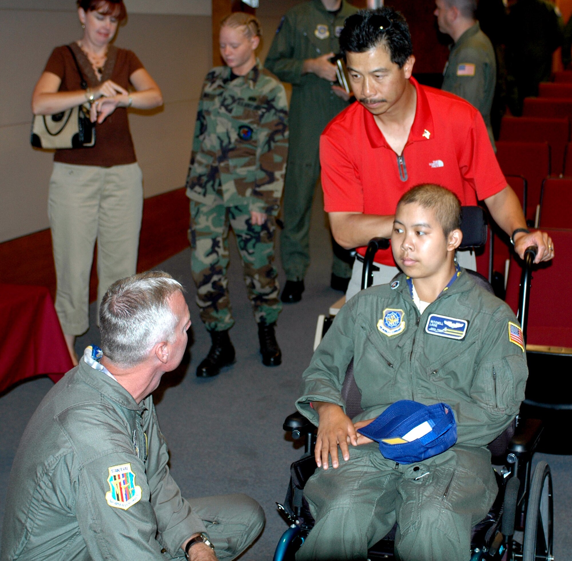 Mitchell Louie and his father, David, speak with Senior Master Sgt. Timothy Nelson, 60th Operations Group, after receiving his mission brief for the day. As part of the "Pilot for the Day" program, Mitchell experienced what it is like to live a day in the life of a pilot. (U.S. Air Force photo/Airman 1st Class Kristen Rohrer)