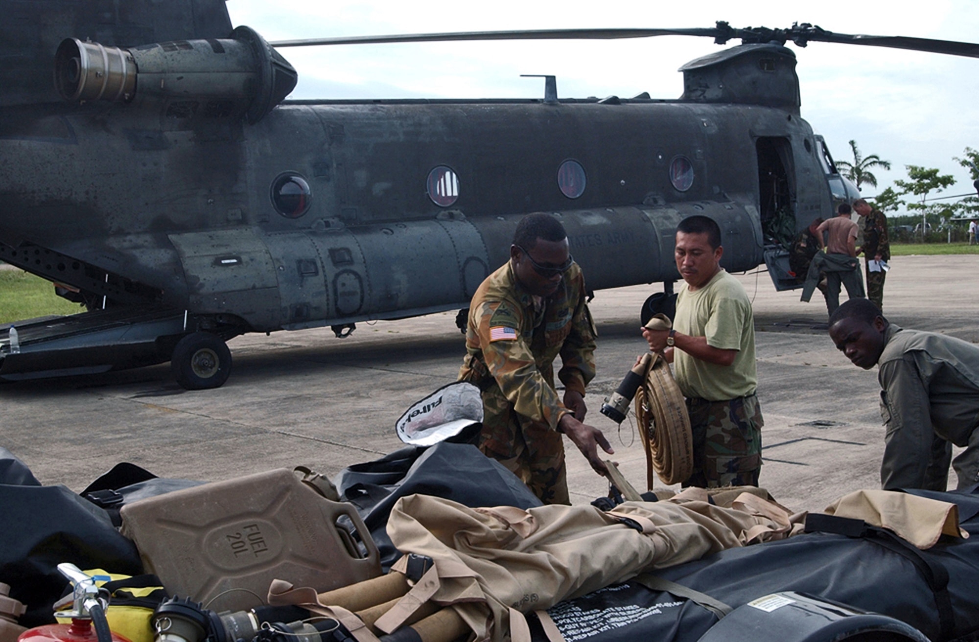 Army Sgt. Barry Baptiste loads cargo onto a trailer with the help of soldiers from the Belizean Defense Force in Belize City, Belize, Aug. 21.  Sergeant Baptiste is here with approximately 20 U.S. Soldiers and Airmen serving on an initial assessment team following the landfall of Hurricane Dean. He is a fuels specialist assigned to the 1st Battalion, 228th Aviation Regiment at Soto Cano Air Base, Honduras. (U.S. Air Force photo/Tech. Sgt. Sonny Cohrs) 