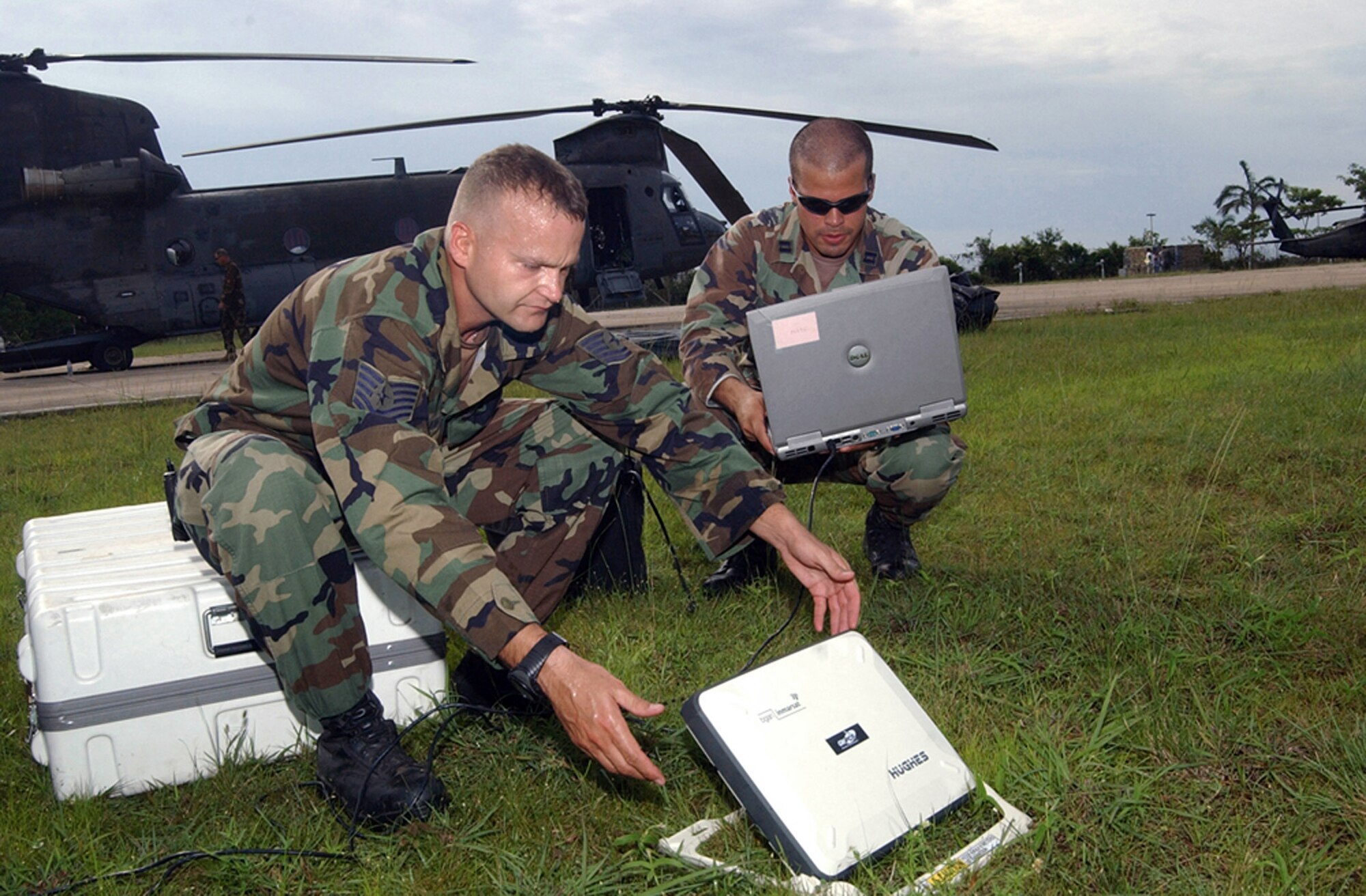 Tech. Sgt. Russell Fairbanks (left) and Capt. Ernesto Garcia set up a broadband global access network system shortly after landing at Belize City, Belize, to establish Internet and e-mail access for communication with Joint Task Force-Bravo at Soto Cano Air Base, Honduras. The two are part of a group of approximately 20 Soldiers and Airmen deployed here to provide an initial assessment of the country following Hurricane Dean Aug. 21.  Sergeant Fairbanks and Captain Garcia are assigned to J6 Communications at Soto Cano AB. (U.S. Air Force photo/Tech. Sgt. Sonny Cohrs) 