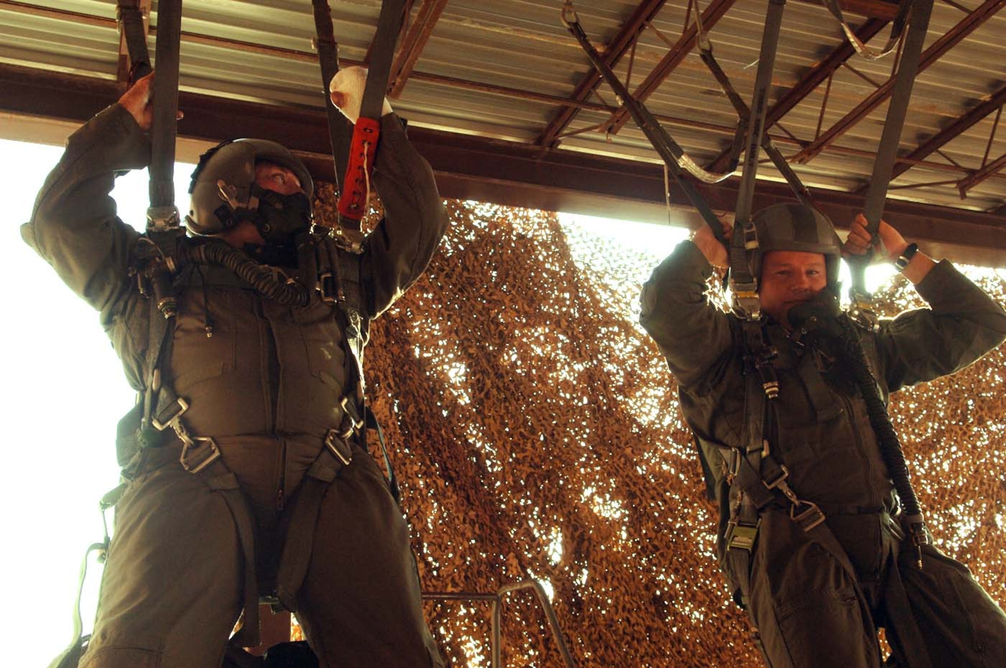 Tech. Sgt. Israel DelToro and Master Sgt. Eric Brandenburg do the hanging portion of their parachute training before getting a flight in a T-38 Talon Aug. 17. The two sergeants were at Holloman to tell Airmen their war stories. (U.S. Air Force photo/Airman 1st Class Tiffany Trojca)