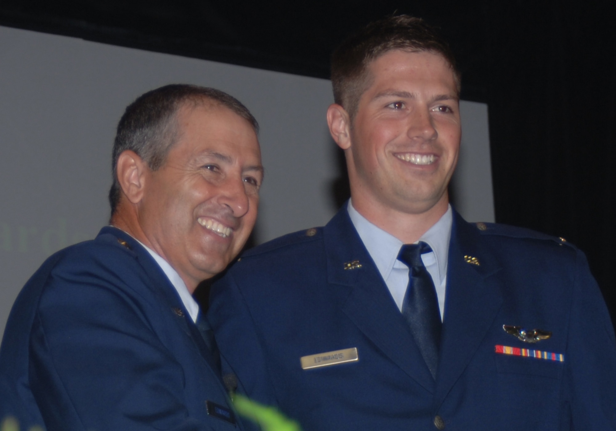 Major Gen. Mike Edwards, Adjutant General for Colorado National Guard, smiles with his son, 2nd Lt. James Edwards, after pinning his son's pilots wings on him at the graduation of Specialized Undergraduate Pilot Training class 07-13 Aug. 17. General Edwards played a dual role in the graduation, he was the keynote speaker as well as the proud parent of one of the Air Force's newest pilots. (U.S. Air Force photo by Airman 1st Class Danielle Powell)