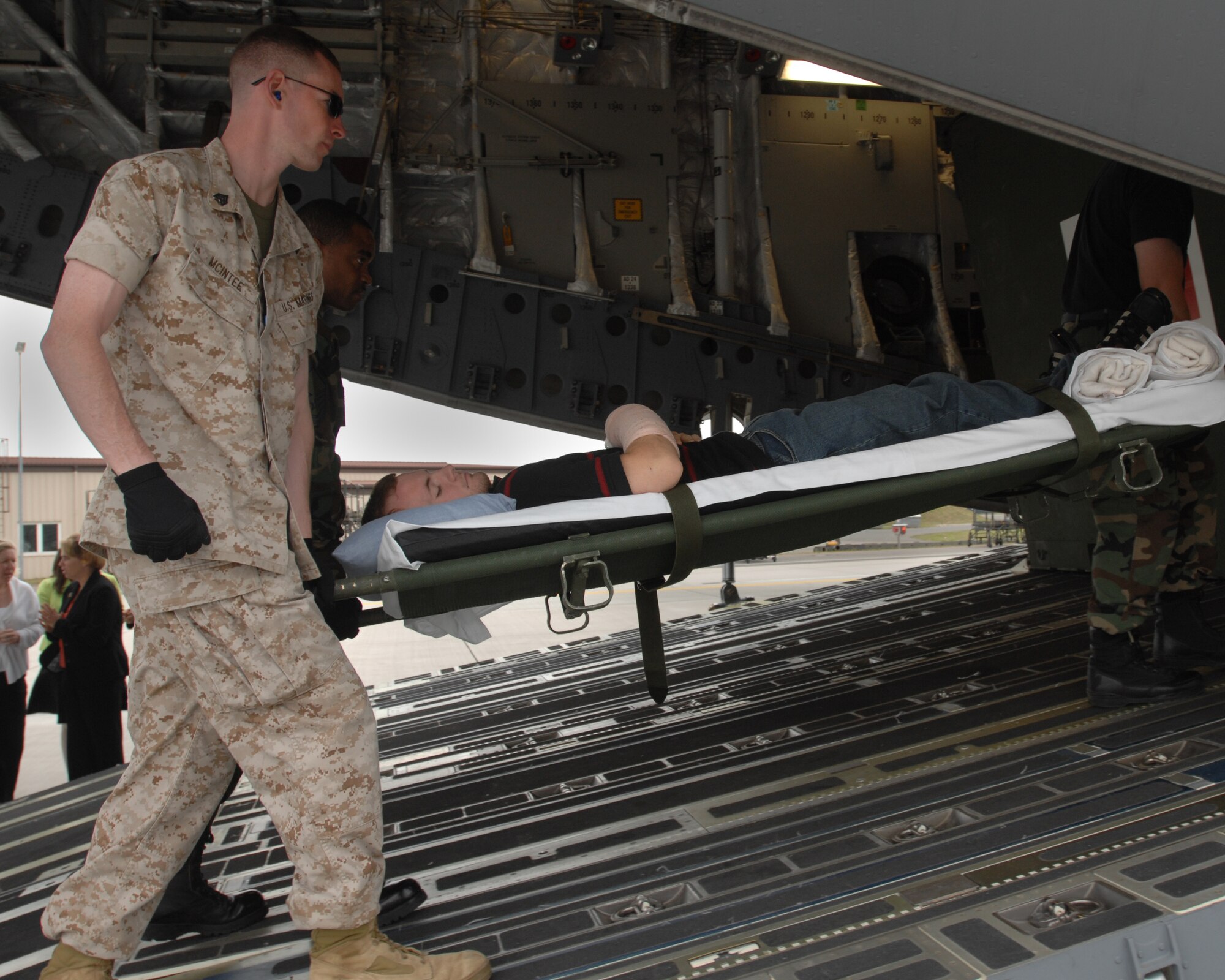 Marine Sgt. Jason McIntee does his part in helping load an areomedical evacuation flight August 21, 2007 at Ramstein Air Base Germany. (U.S. Air Force photo/Airman 1st Class Kenny Holston)