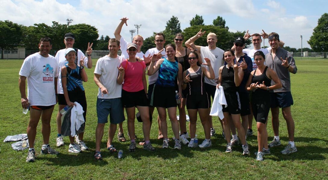 MISAWA AIR BASE, Japan -- Misawa people stop to pose for a photograph after completing Misawa's 4th Annual Wild Weasel Triathlon Aug. 19 here. Forty-five participants swam 500m (20 laps each) at the Himberg Pool; biked 8.5 miles from Himberg pool; ran 3.5 miles from Himberg pool to Fire Station #1 and back, ending at soccer field. Participants competed in three divisions -- masters (men-ages 37 up); open (men-ages 36 down); and female (women-ages 18 up). Winners were: Masters - Yoshiyu Maruyama with 58:05 (JSDF); and the runner-up - Tom Viner with 58:40 (CTF-72); Men's open - Mike Chmielewski with 54:43 (13th Fighter Squadron FS); and the runner-up - Jason Miller with 101:39 (14th Fighter Squadron); Women's Open - Cathy Wu with 59:35, (MSOC); and the runner up - Cris Boswell with 108:25, (family member). (U.S. Air Force photo)