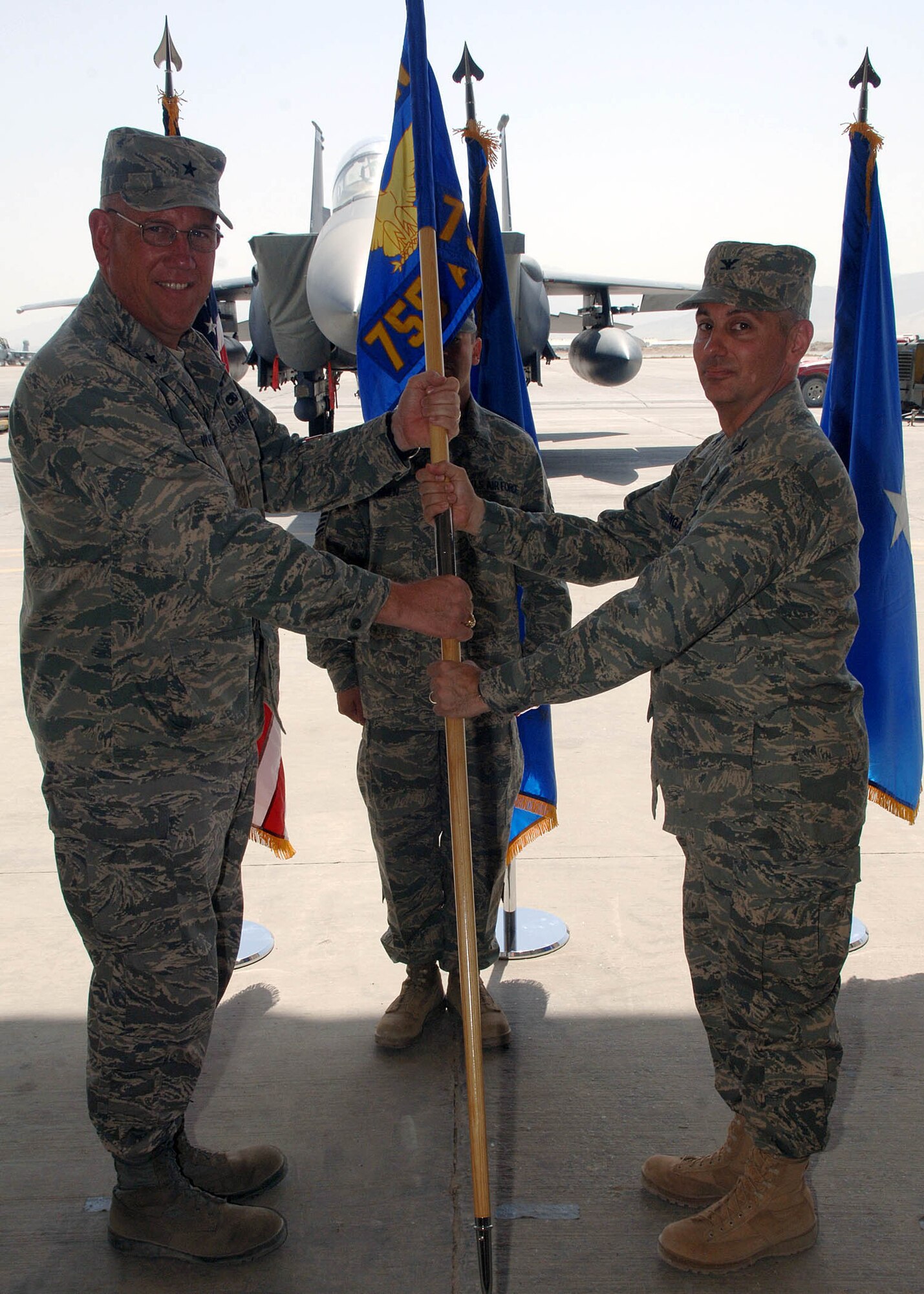 Col. Thomas Huizenga (right), 755th Air Expeditionary Group commander, accepts the group's guidon from Brig. Gen. Bill Hyatt, 455th Air Expedtionary Wing commander, signifying the change of command for the group in a ceremony August 21 at Bagram Airfield, Afghanistan. (U.S. Air Force photo by Staff Sgt. Craig Seals)