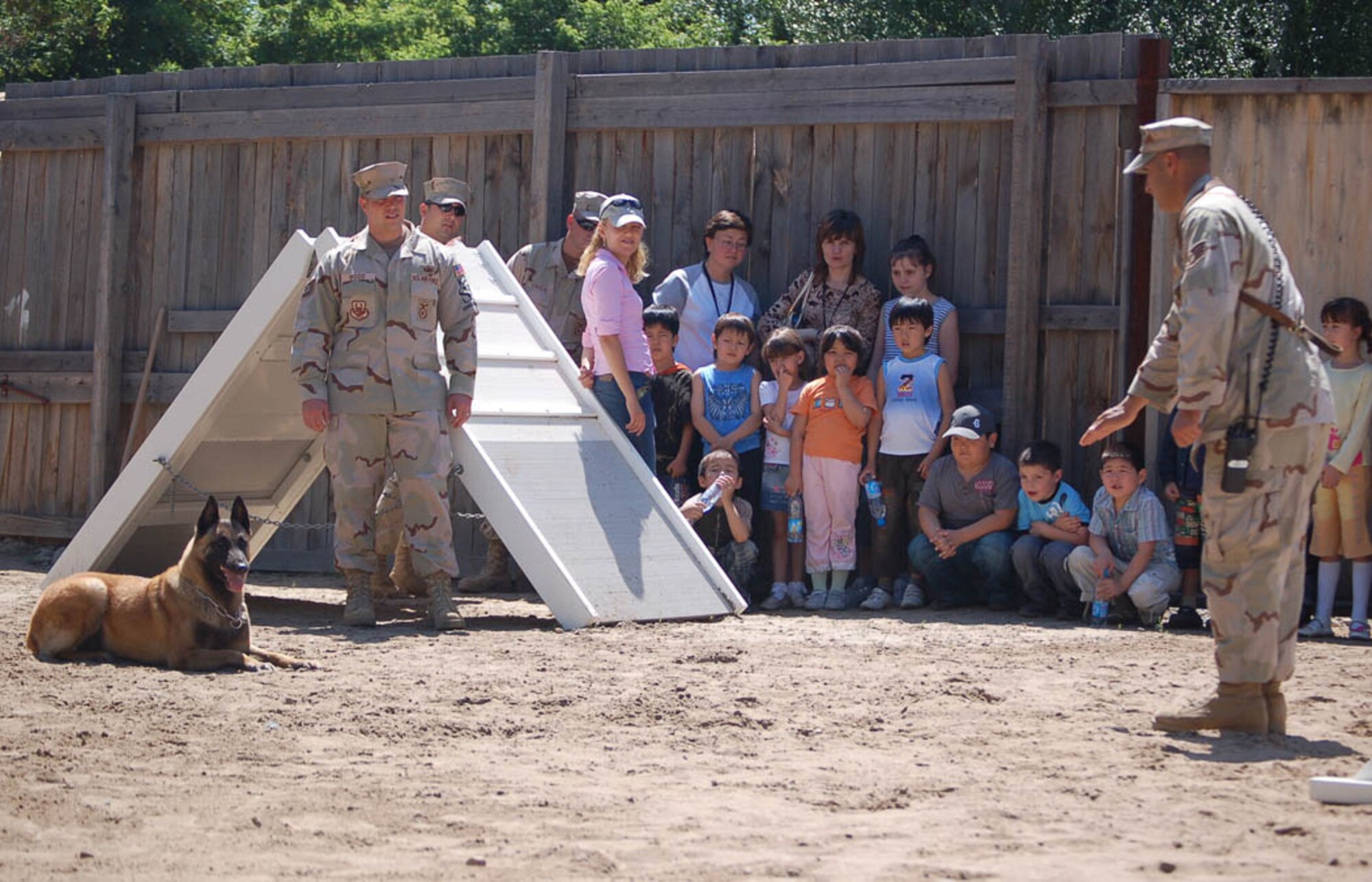 MANAS AIR BASE, Kyrgyz Republic -- Staff Sgt. Manuel Garcia and Jimmy, his K-9 partner, along with another Airman provide a demonstration to 15 first graders from Kelechek Elementary School during a school tour here. The group visited explosive ordnance disposal team, the K-9s and the fire department.  Sergeant Garcia and Jimmy are assigned to the 376th Expeditionary Security Forces Squadron and are deployed from Misawa Air Base, Japan's, 35th Security Forces Squadron's K-9 unit.  To learn more about Sergeant Garcia and Jimmy's mission there, click on the related link and listen to the radio interview with Detachment 12, American Forces Network Mass Communication Petty Officer 1st Class James Stilipec. (U.S. Air Force photo by Staff Sgt. Les Waters)
