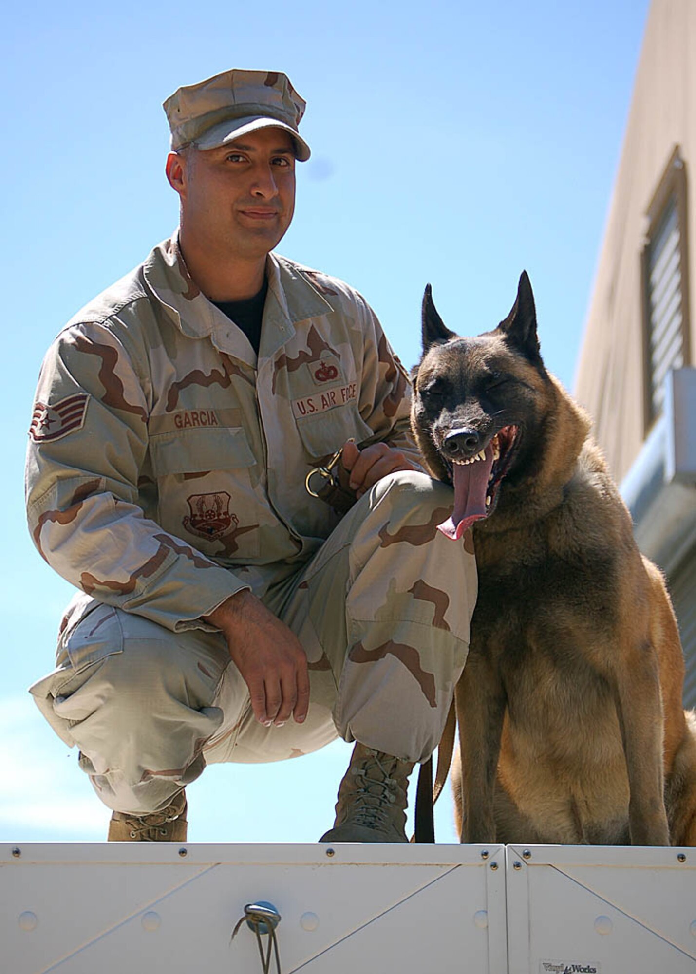 MANAS AIR BASE, Kyrgyz Republic -- Staff Sgt. Manuel Garcia and Jimmy, his K-9 partner, pose for a photo before running the obedience course here recently. The 376th Expeditionary Security Forces Squadron team is deployed from Misawa Air Base, Japan's, 35th Security Forces Squadron's K-9 unit.  To learn more about Sergeant Garcia and Jimmy's mission there, click on the related link and listen to the radio interview with Detachment 12, American Forces Network Mass Communication Petty Officer 1st Class James Stilipec. (U.S. Air Force photo by Staff Sgt. Les Waters)
