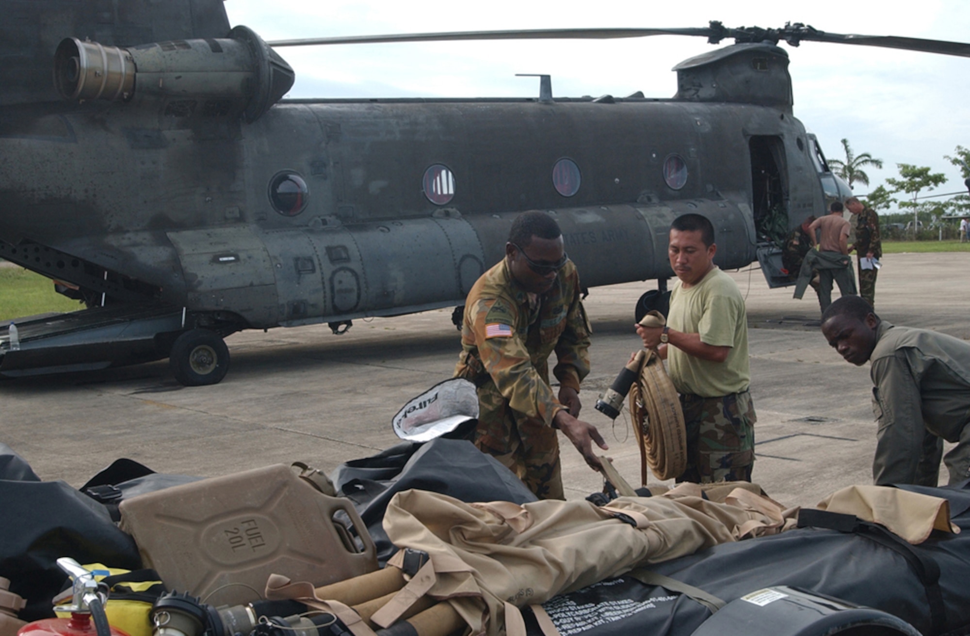 BELIZE CITY, Belize ? Army Sgt. Barry Baptiste, a fuels specialist assigned to the 1st Battalion, 228th Aviation Regiment at Soto Cano Air Base, Honduras, loads cargo onto a trailer with the help of soldiers from the Belizean Defense Force here Aug. 21.  Sergeant Baptiste, a native of Brooklyn, N.Y., is here with a team of approximately 20 U.S. Soldiers and Airmen serving on an initial assessment team following the landfall of Hurricane Dean.  (U.S. Air Force photo by Tech. Sgt. Sonny Cohrs)                               