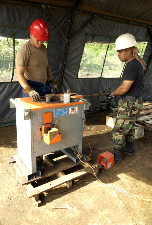ANDERSEN AIR FORCE BASE, Guam - Senior Airman Thomas Agee and Tech. Sgt. John Sablan, both from the 554th RED HORSE Squadron, bend a piece of rebar at Northwest Field, Aug. 22, 2007.  (Photo by Senior Airman Miranda Moorer/36th Wing Public Affairs)                