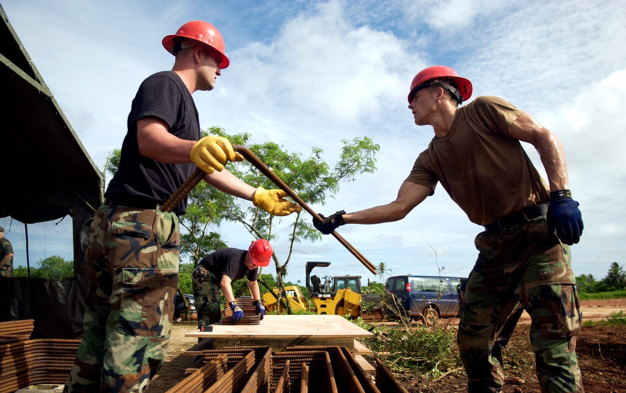 ANDERSEN AFB, GUAM - Staff Sgt. Jeremy Reneau passes a piece of rebar to Airman 1st Class Christopher David, 554th RED HORSE Squadron, at Northwest Field, Aug. 22, 2007.  The 554th RED HORSE Squadron is currently building new infastructure on Northwest Field. (Photo by Senior Airman Miranda Moorer/36th Wing Public Affairs)