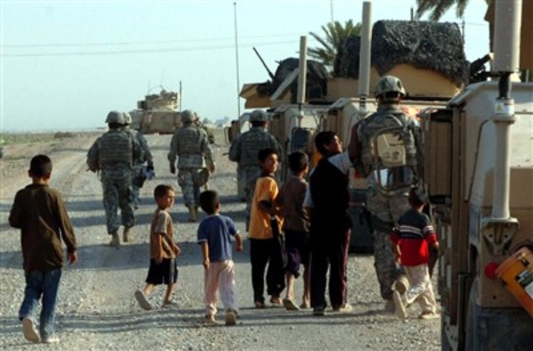 Local children from Sheik Mazen Village, an area within the Diyala River Valley, follow Coalition forces from the 3rd Brigade Combat Team, 1st Cavalry Division, as they return to their vehicles after clearing operations in support of Operation Lightning Hammer, Aug. 22, 2007.