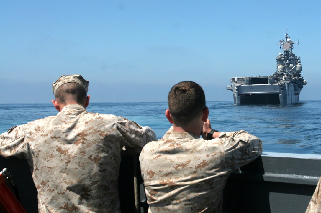 OFF THE COAST OF MARINE CORPS BASE CAMP PENDLETON, Calif.,?Marines with Combat Logistics Battalion 11 gaze at the USS Tarawa as they make a ship-to-shore movement during a humanitarian aid operation exercise Aug. 23. The Marines and sailors of CLB-11, 11th Marine Expeditionary Unit sprang into action in response to a simulated disaster in an Iraqi village during the MEU?s first at-sea period. CLB-11 responded by setting up a food and water distribution site and a medical facility to mitigate the suffering of the village.