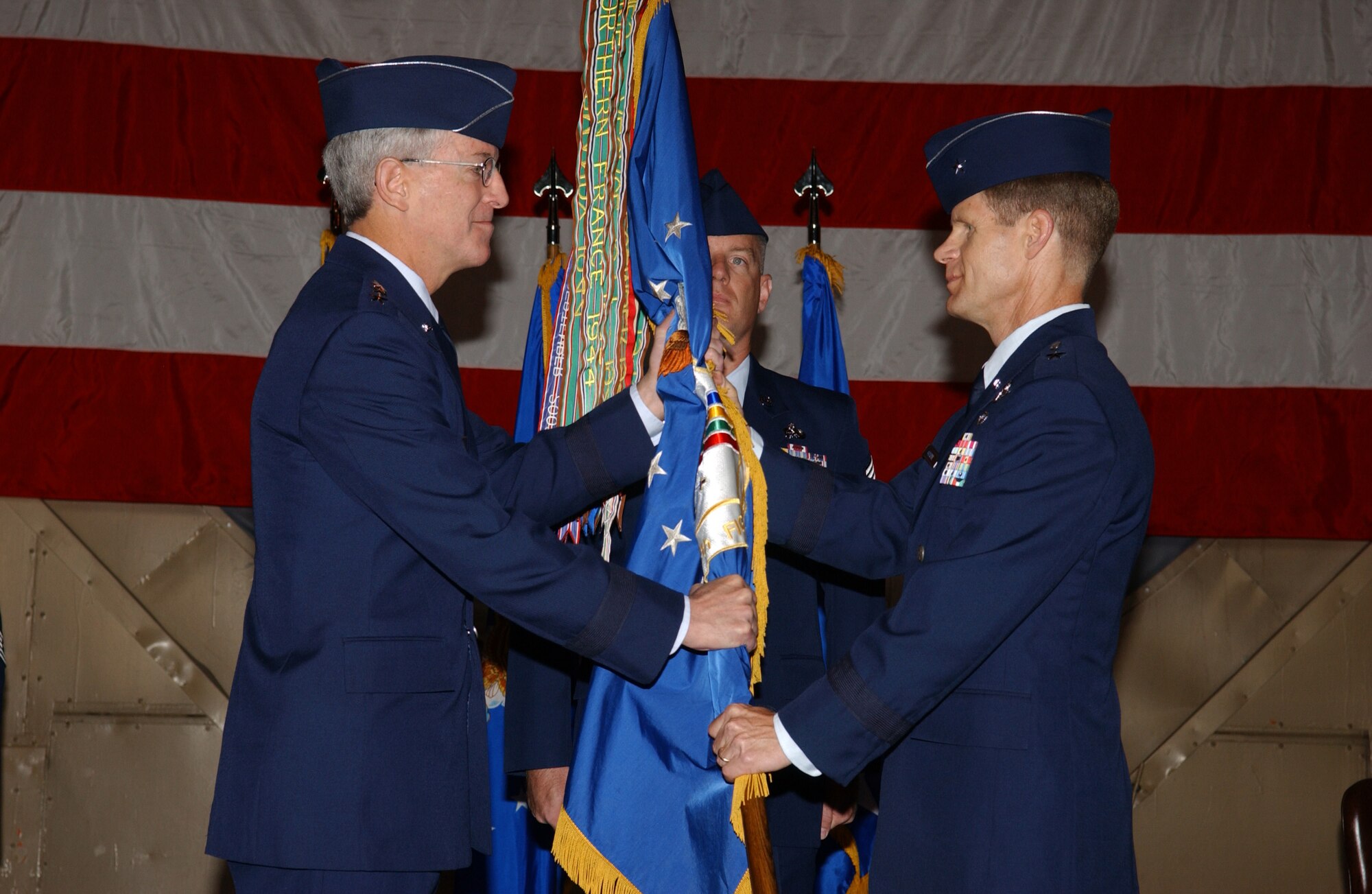 EIELSON AIR FORCE BASE, Alaska -- Lt. Gen. Douglas Fraser, 11th Air Force commander passes the guidon to Brig. Gen. Mark Graper for the 354th Fighter Wing change of command ceremony Aug. 22 at the Thunderdome. The guidon symbolizes the relinquishment of authority from the outgoing commander to the incoming commander. (U.S. Air Force Photo by Airman 1st Class Jonathan Snyder)(Released)