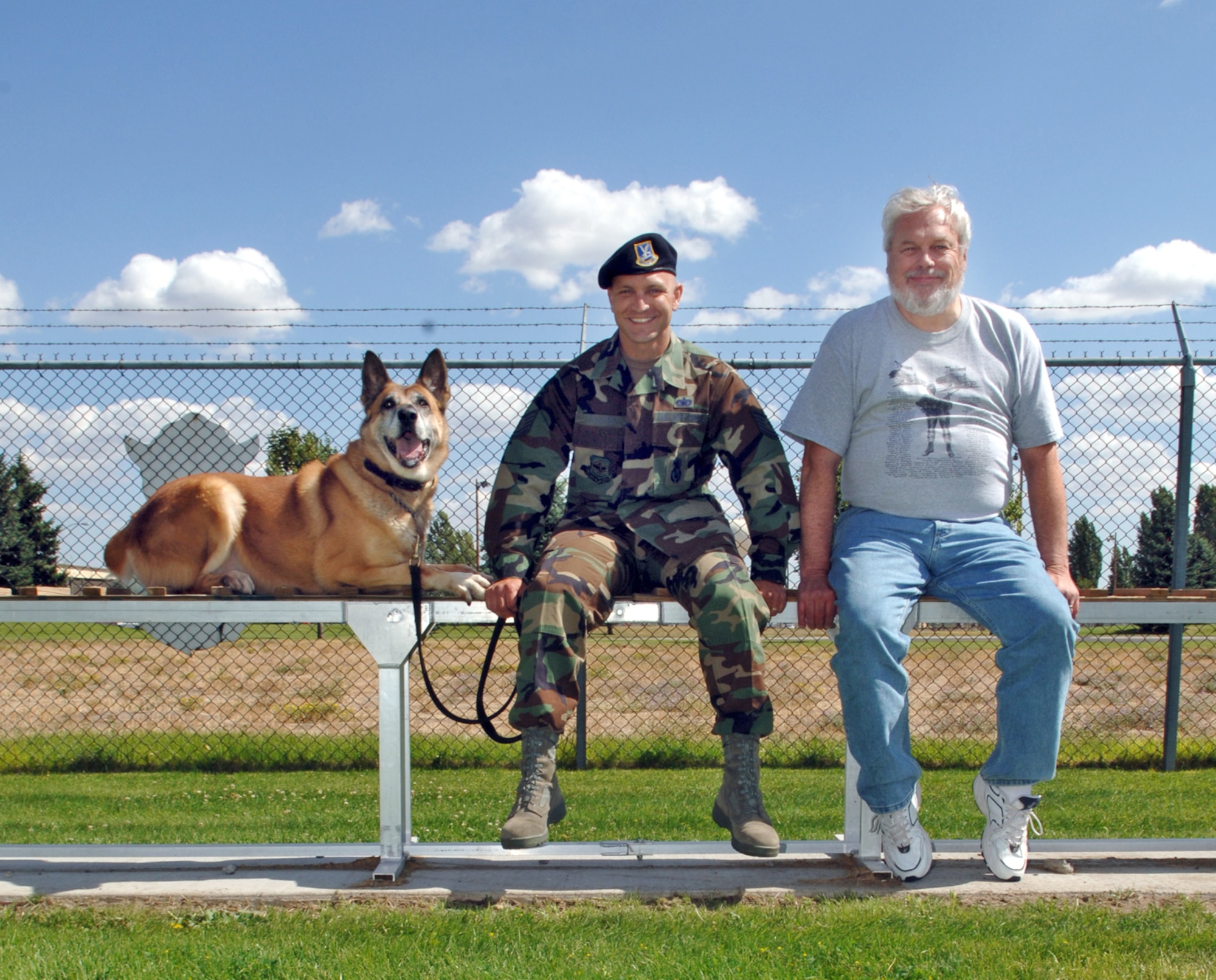 FAIRCHILD AIR FORCE BASE, Wash. -- After a day of touring the military working dog facilities here and putting Tico, a military working dog, through some paces on the obstacle course, Tech. Sgt. Max Talley, 92nd Security Forces Squadron kennel staff, Mr. David Adams and Tico take a break on the dog walk. Mr. Adams, a former dog handler with the 92nd Bomb Wing, was visiting Fairchild nearly 30 after he was stationed here. (U.S. Air Force photo / Airman 1st Class Josh Chapman)