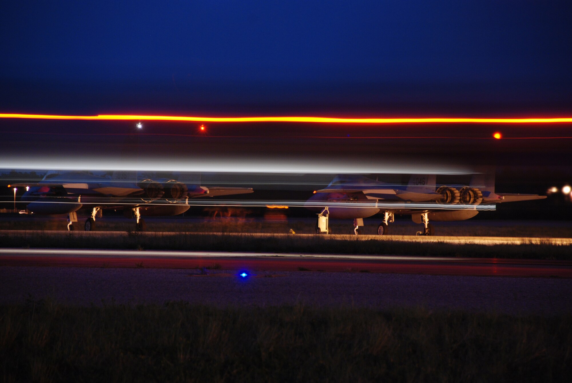 EGLIN AIR FORCE BASE, Fla. -- An F-15C streaks by on the ramp as two 60th Fighter Squadron F-15C Eagles with the 33d Fighter Wing at Eglin AFB, Fla. are going through their final checks before take off during night flying operations Aug. 21. Night flying is a critical element in F-15 pilot training and required on a consistent basis for mission readiness. (U.S. Photo by Staff Sgt. Mike Meares)